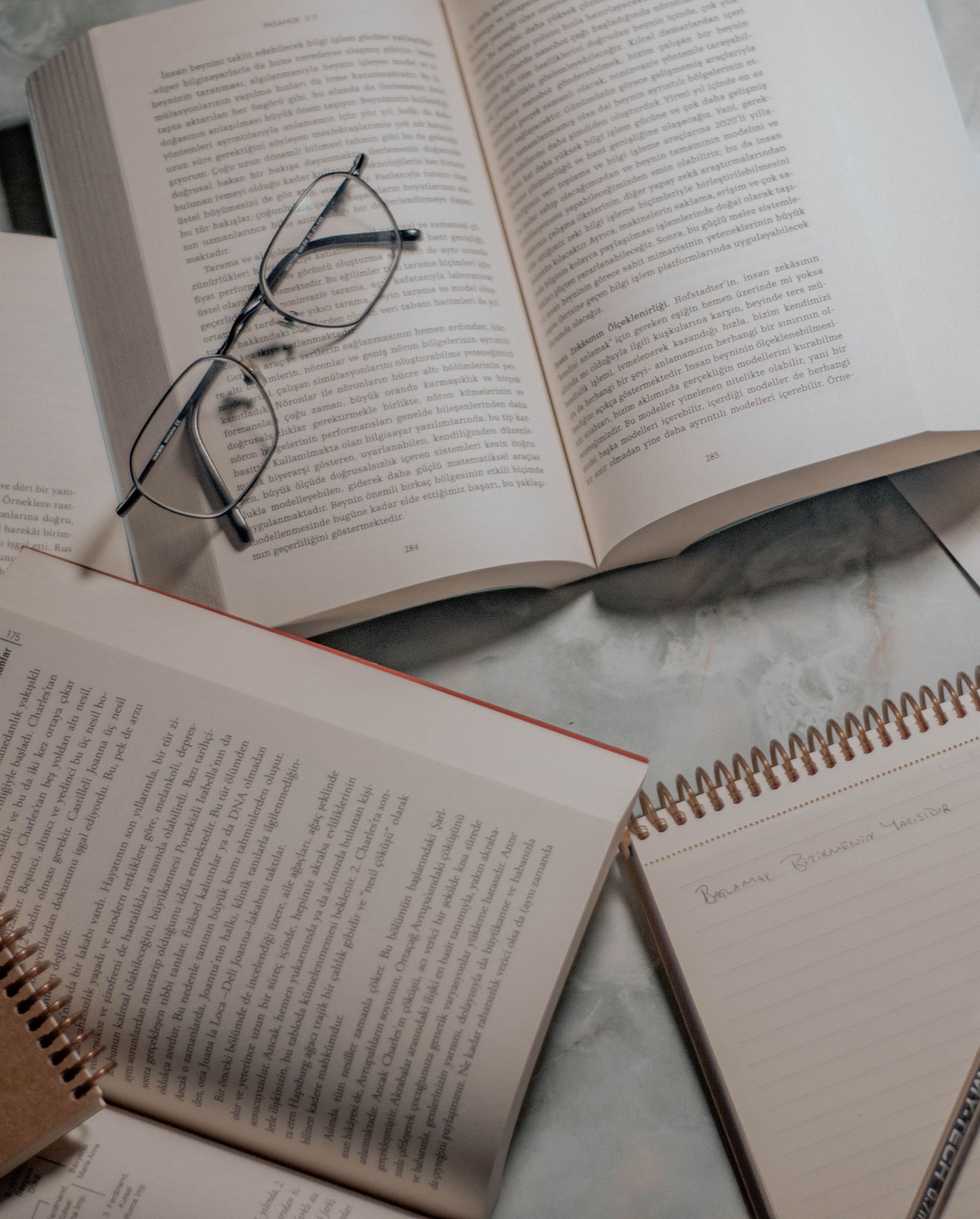 Top view of open books and eyeglasses on a study table