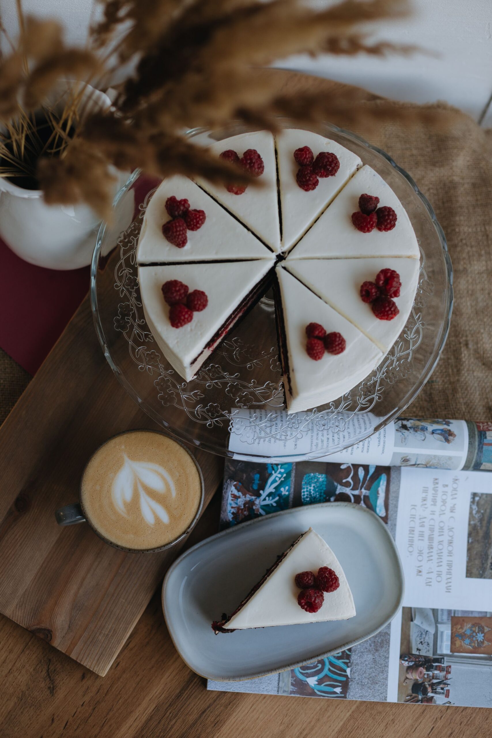 Slice of cake with coffee and flowers on a dark table