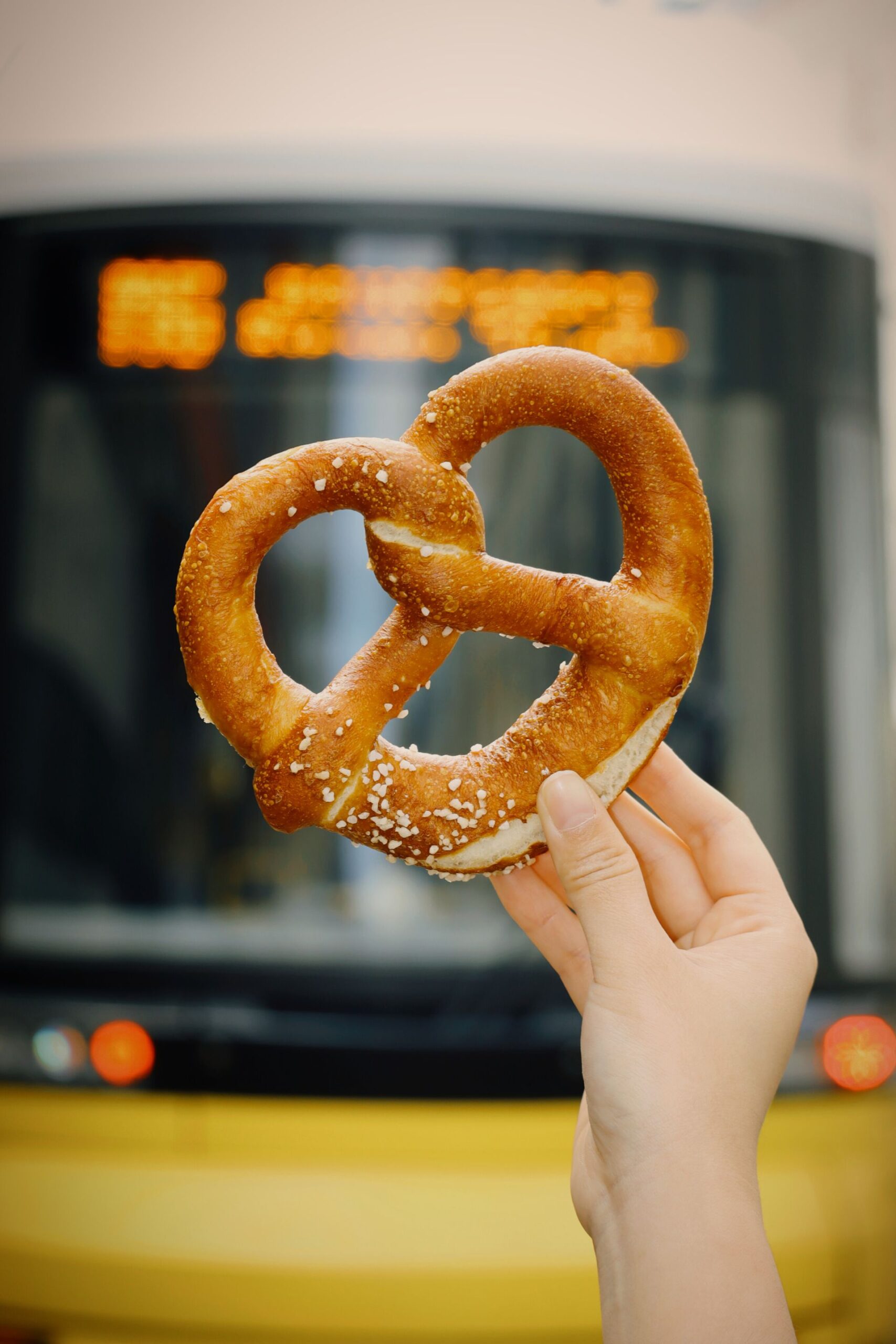 Hand holding a pretzel on a street in Berlin