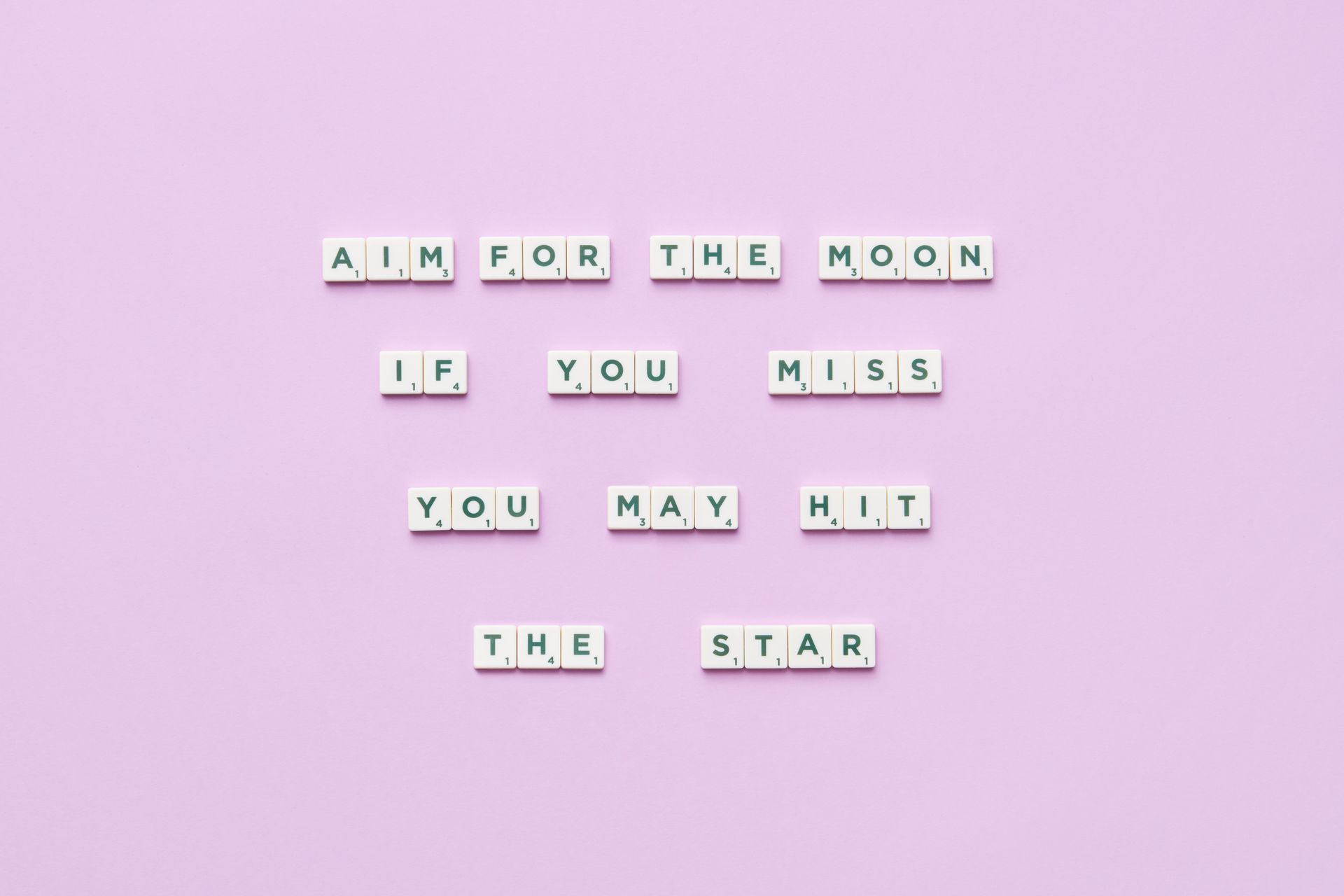 Inspirational message spelled with Scrabble tiles on pastel