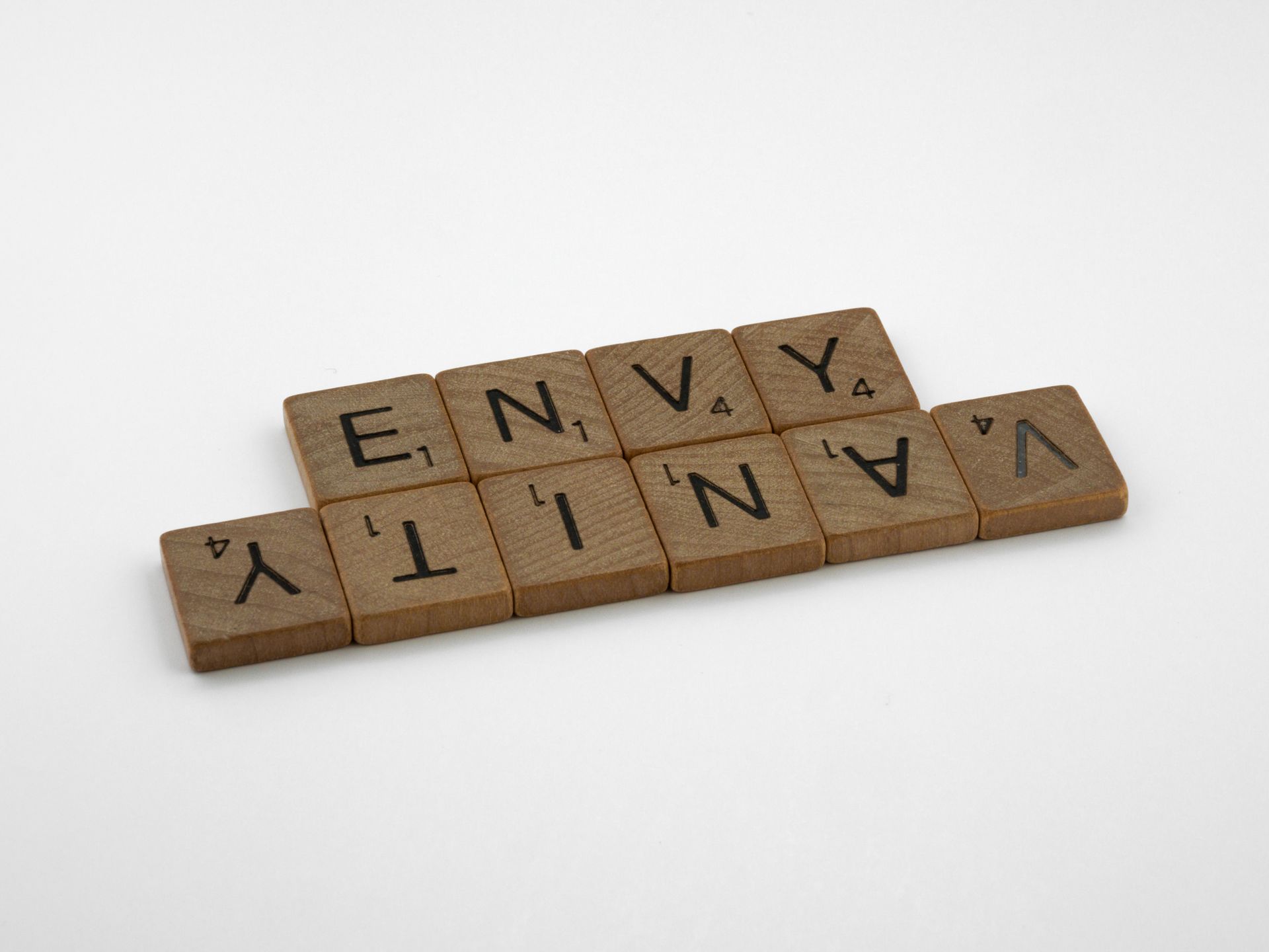 Wooden Scrabble tiles spelling Love is Kind