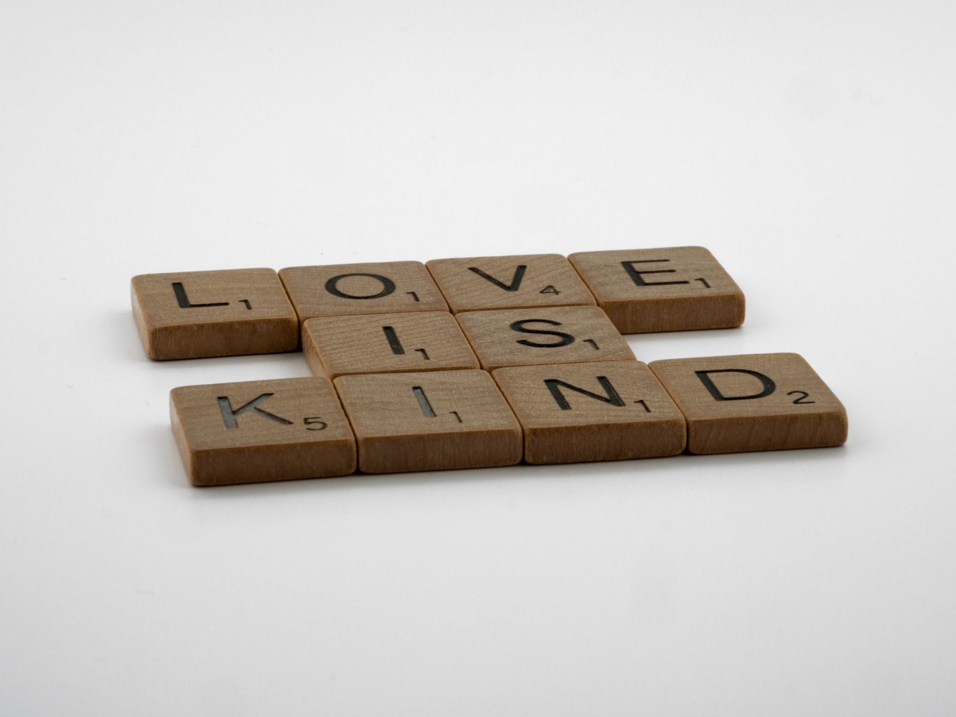 Scrabble letters spelling Love Does Not Boast