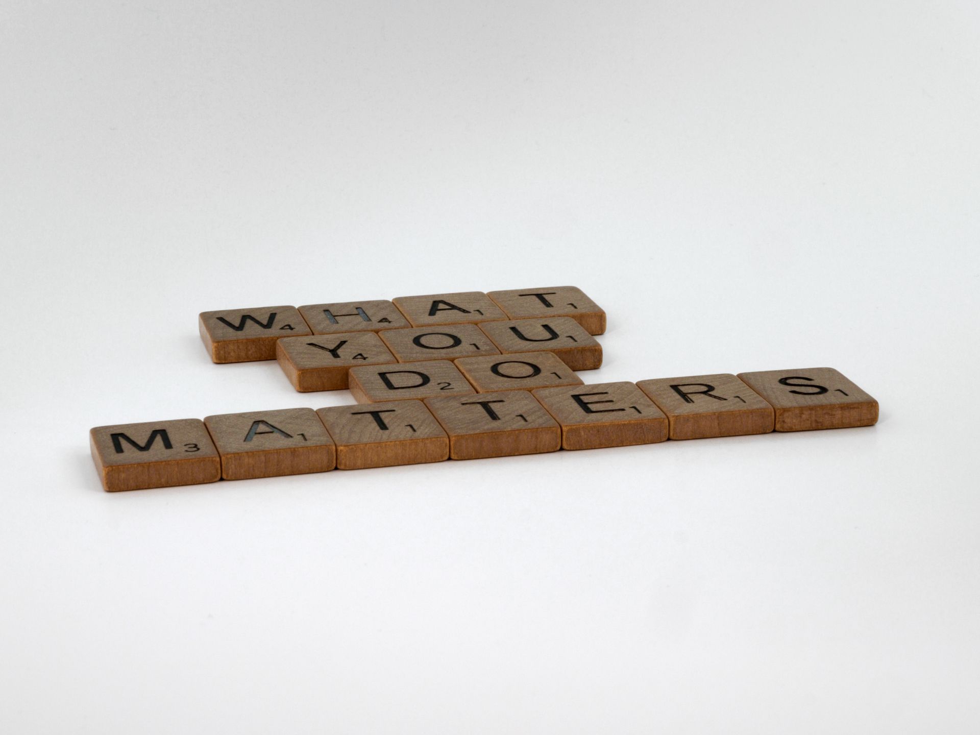 Scrabble tiles spelling What You Do Matters on white
