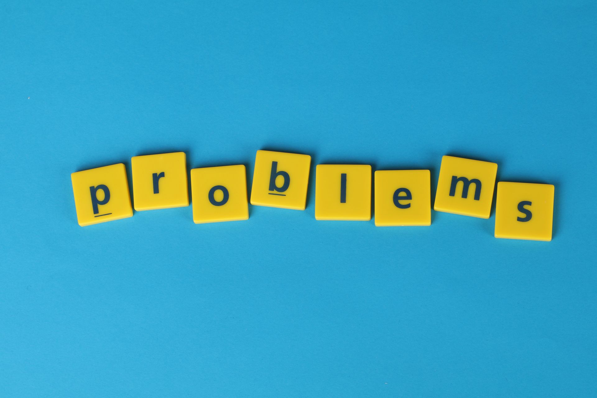 Yellow wooden letter tiles arranged on a blue background
