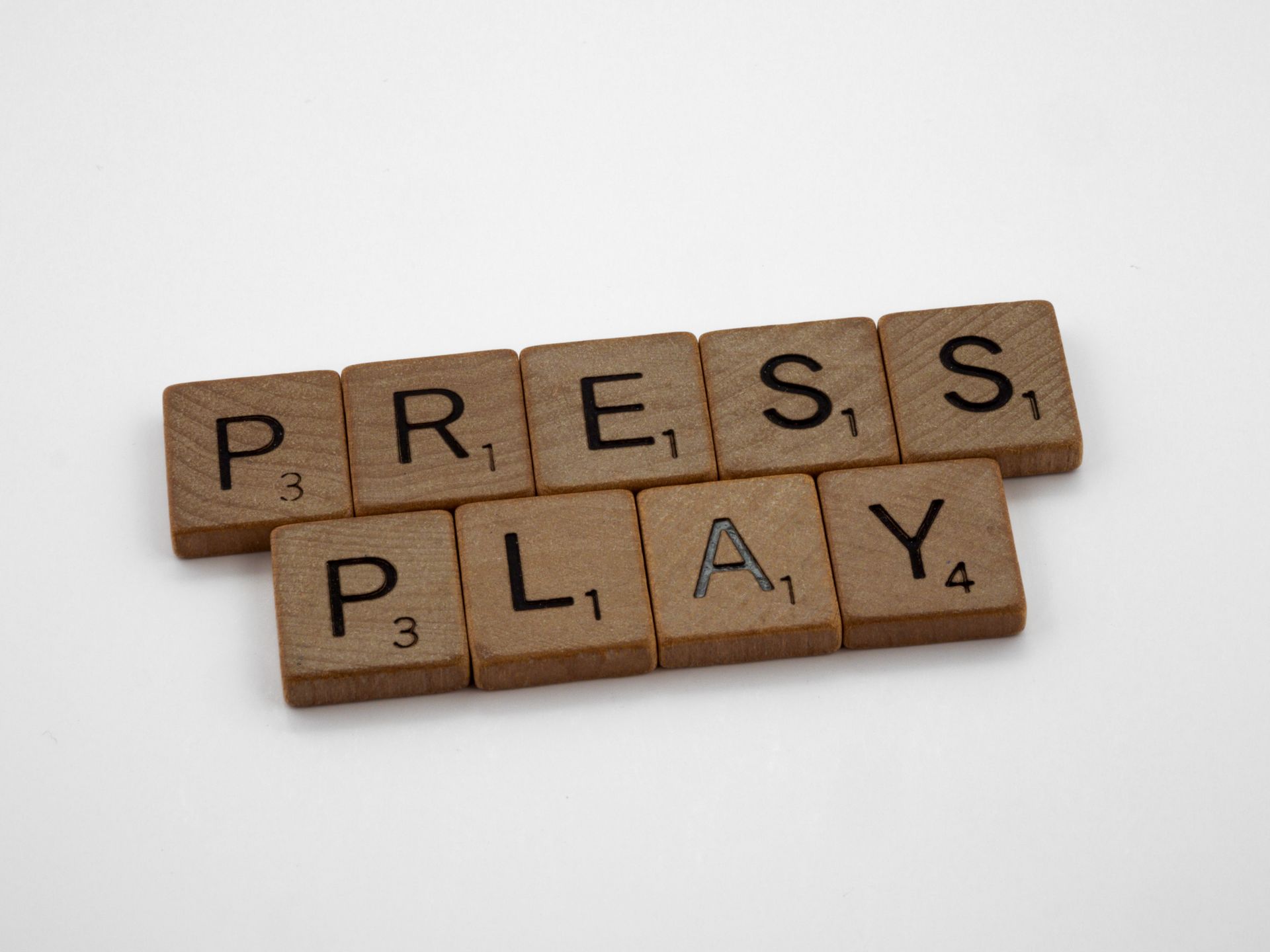 Scrabble letter tiles spread on a white background