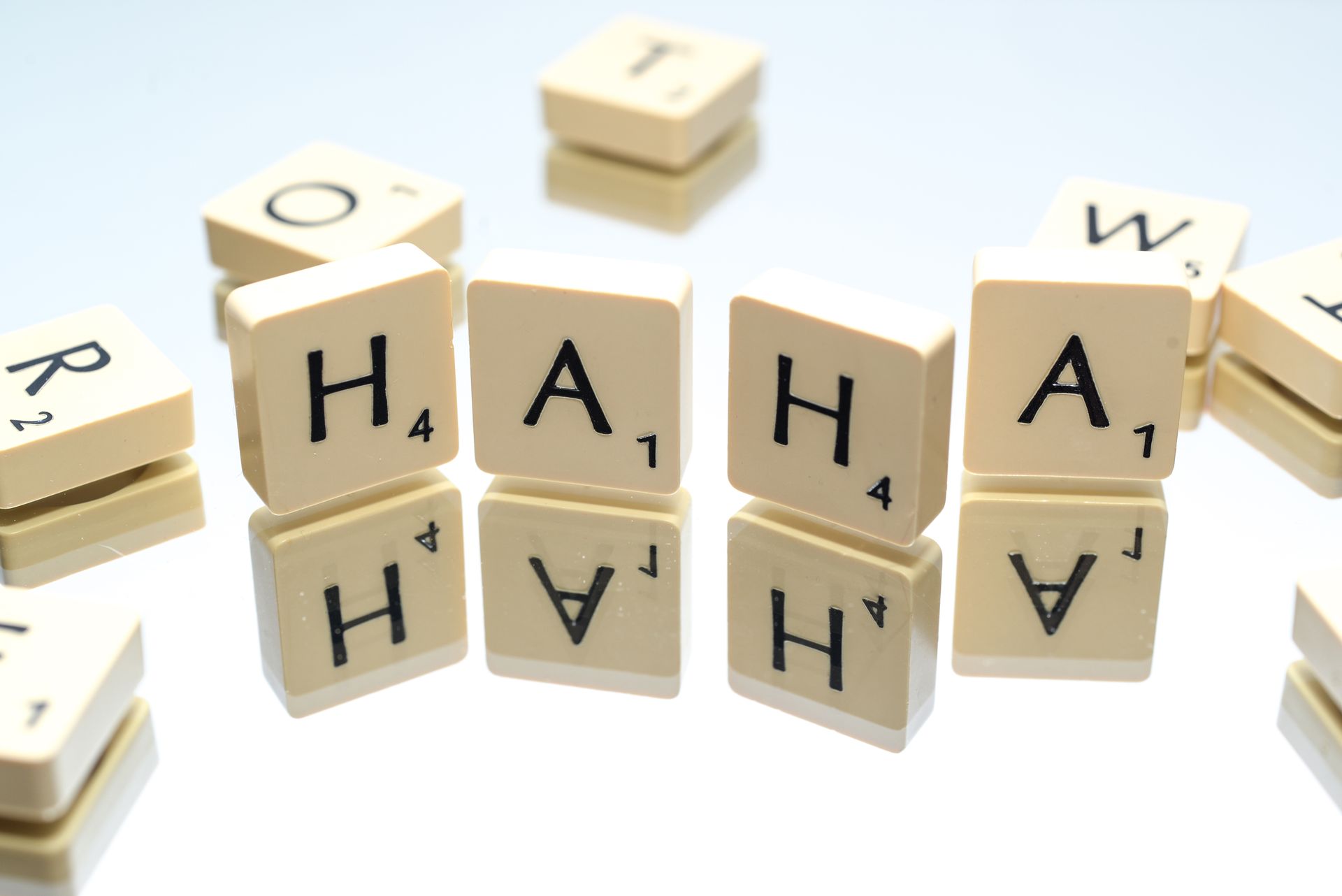 Board game letter tiles spelling words on a reflective surface