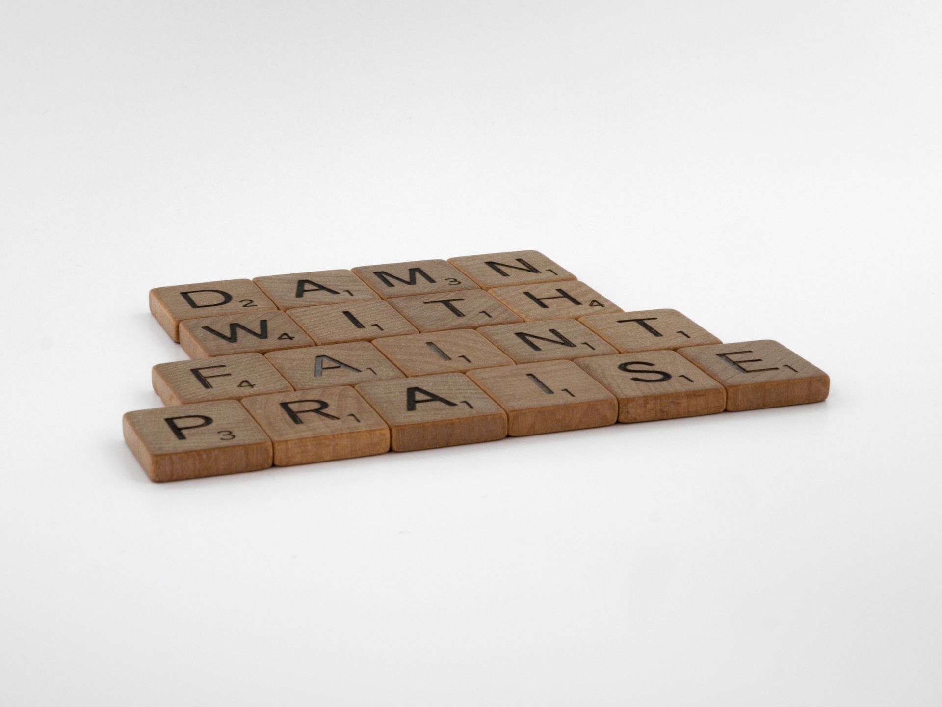Close-up of wooden Scrabble tiles on a white surface