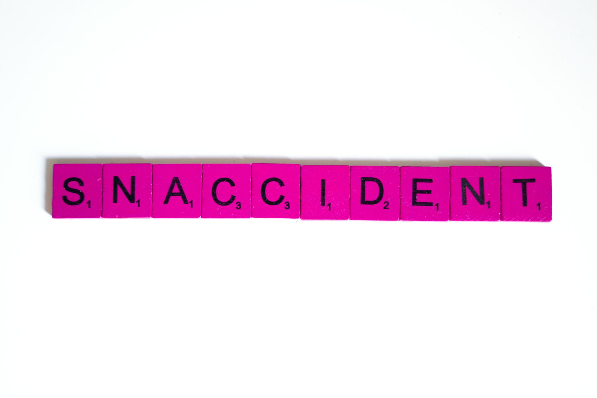 Pink letter tiles in a playful flat lay on a white background