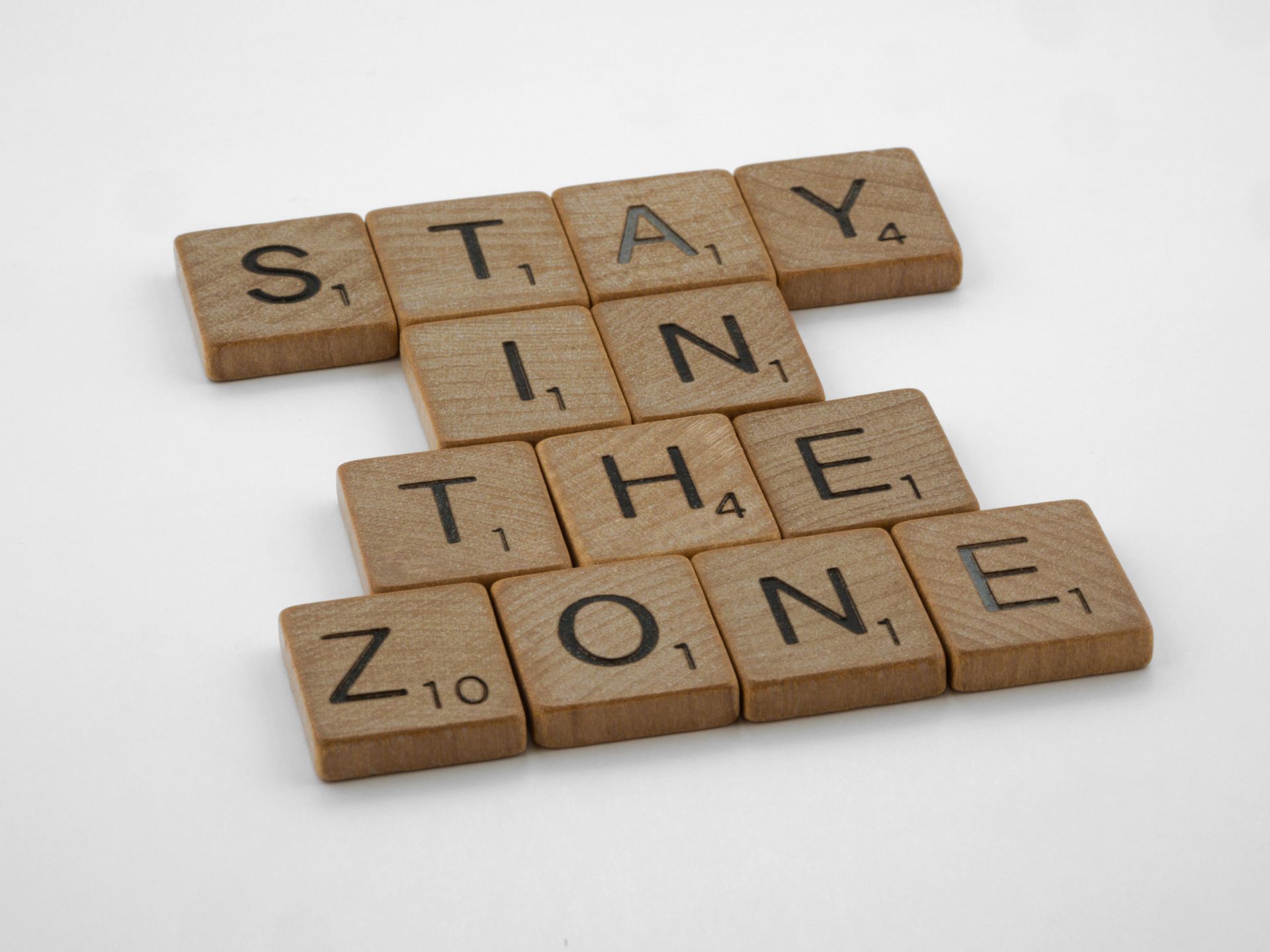Wooden Scrabble tiles spelling words on a white surface