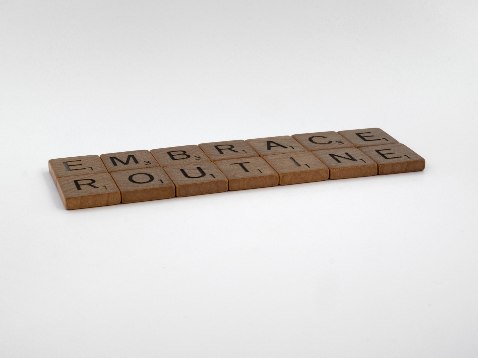Wooden Scrabble tiles spelling words on a white background