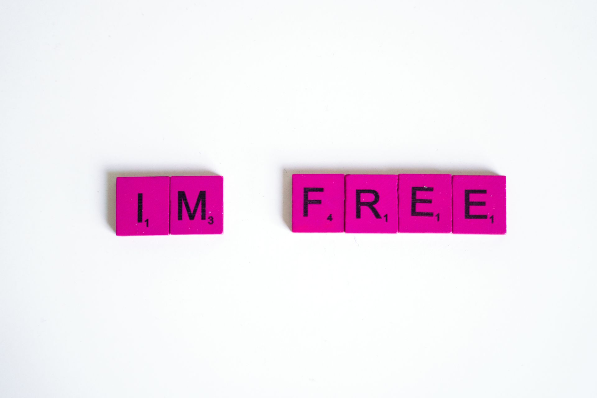 Pink Scrabble tiles on a white background
