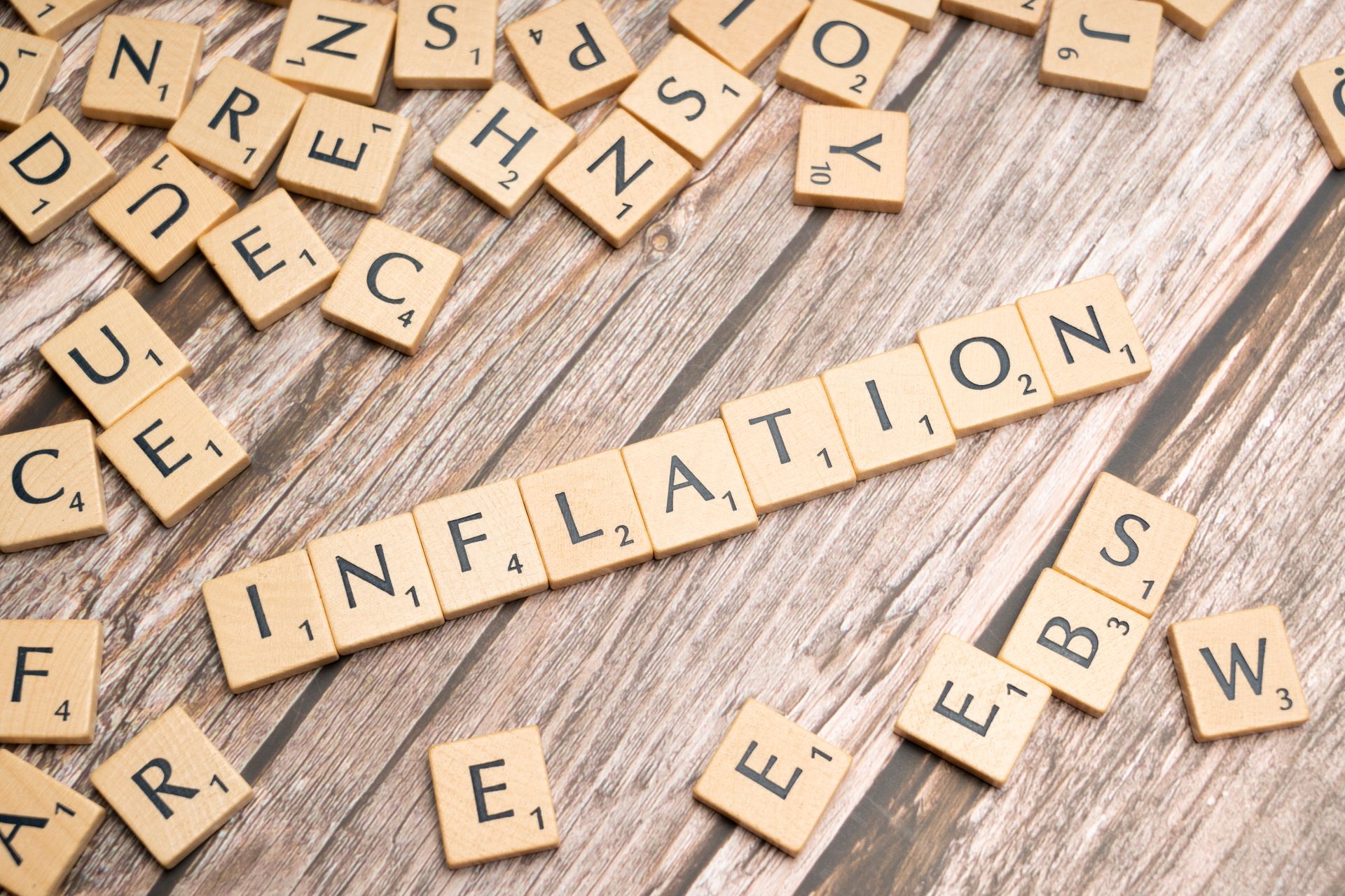 Wooden letter tiles spelling inflation on wood