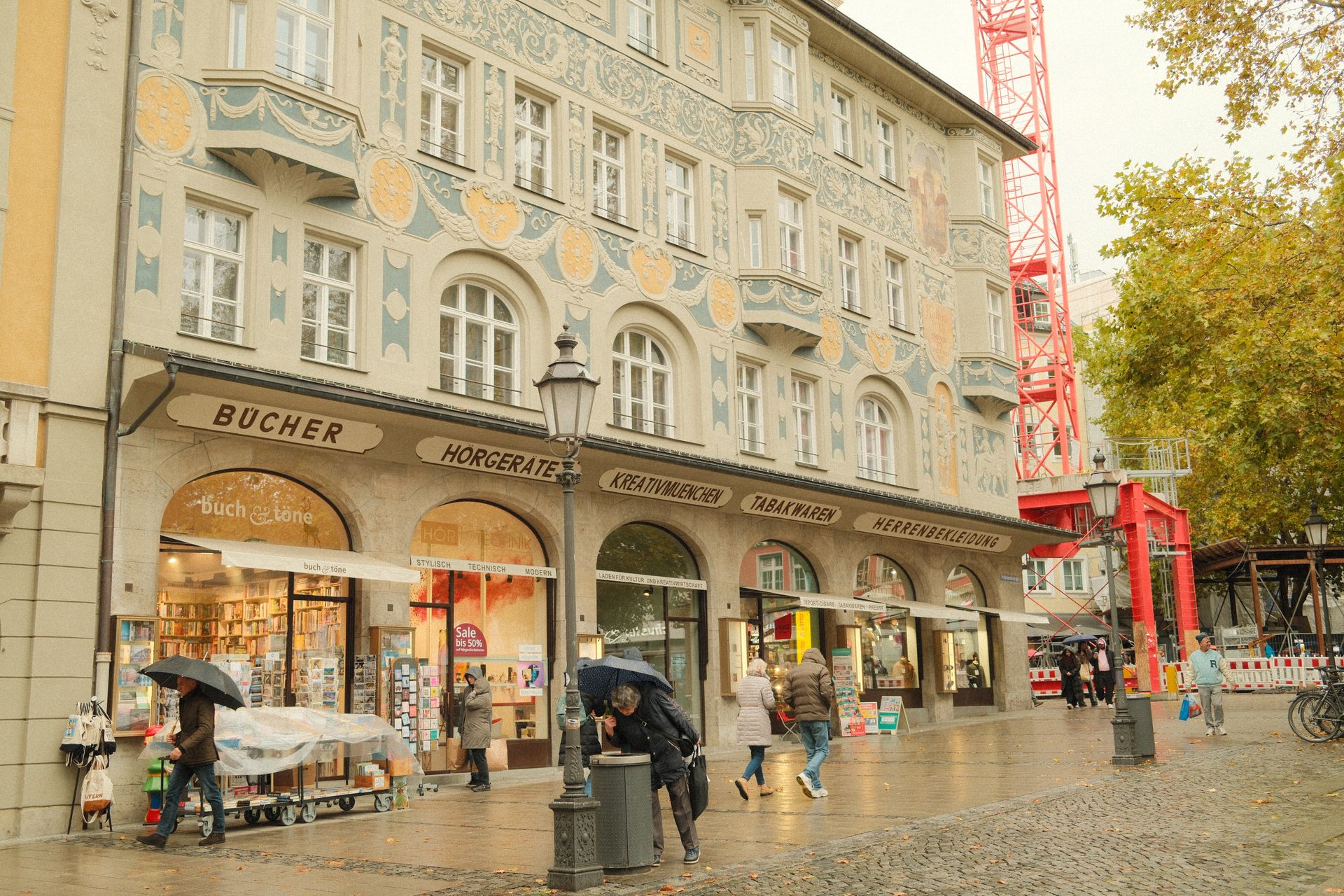 Rainy shopping street in Munich with pedestrians and umbrellas