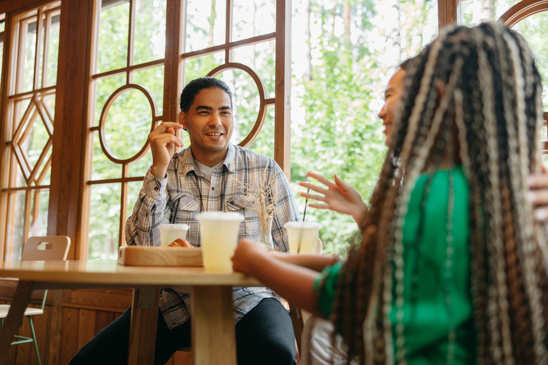 Two people enjoying conversation at a sunlit café table