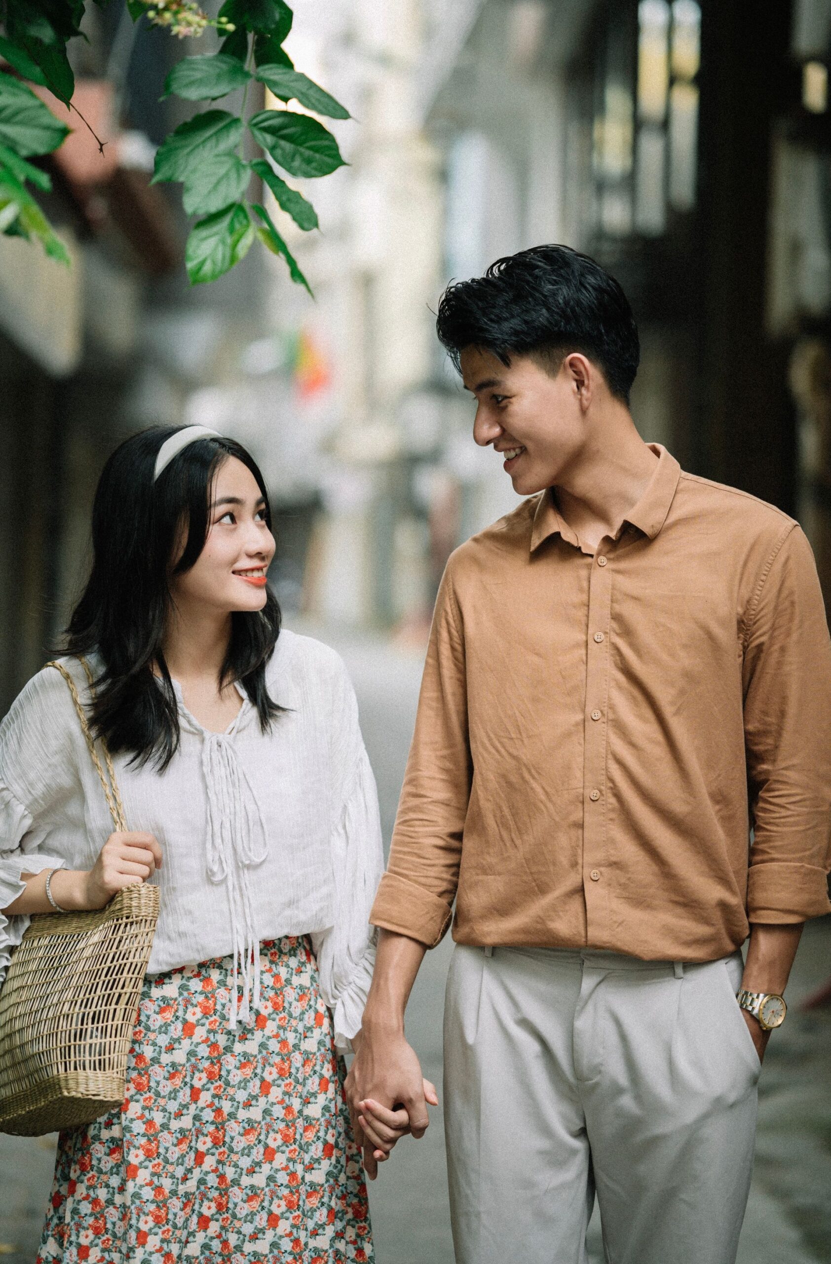 Smiling young couple walking hand in hand on a city street