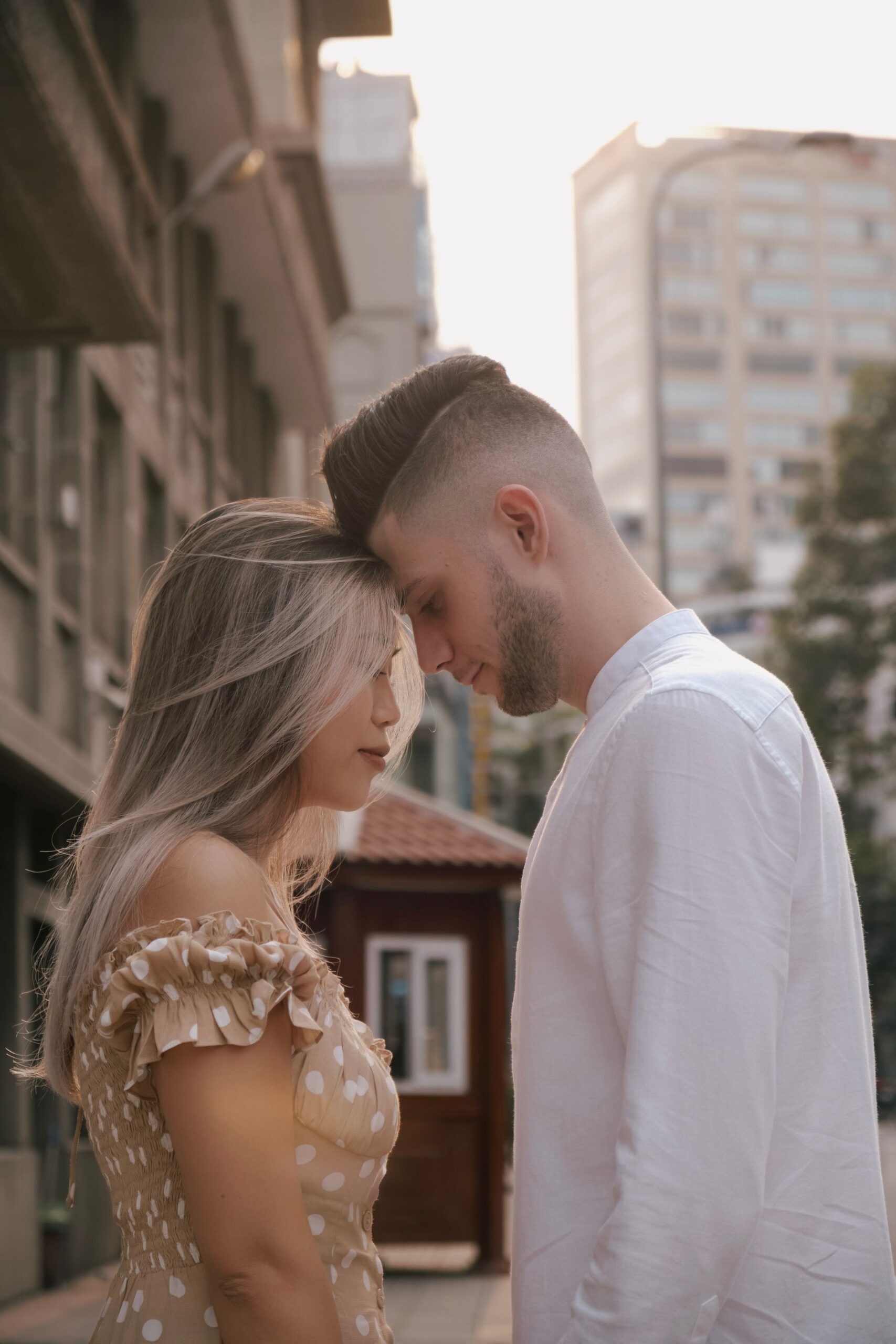 Couple embracing on a city street at sunset