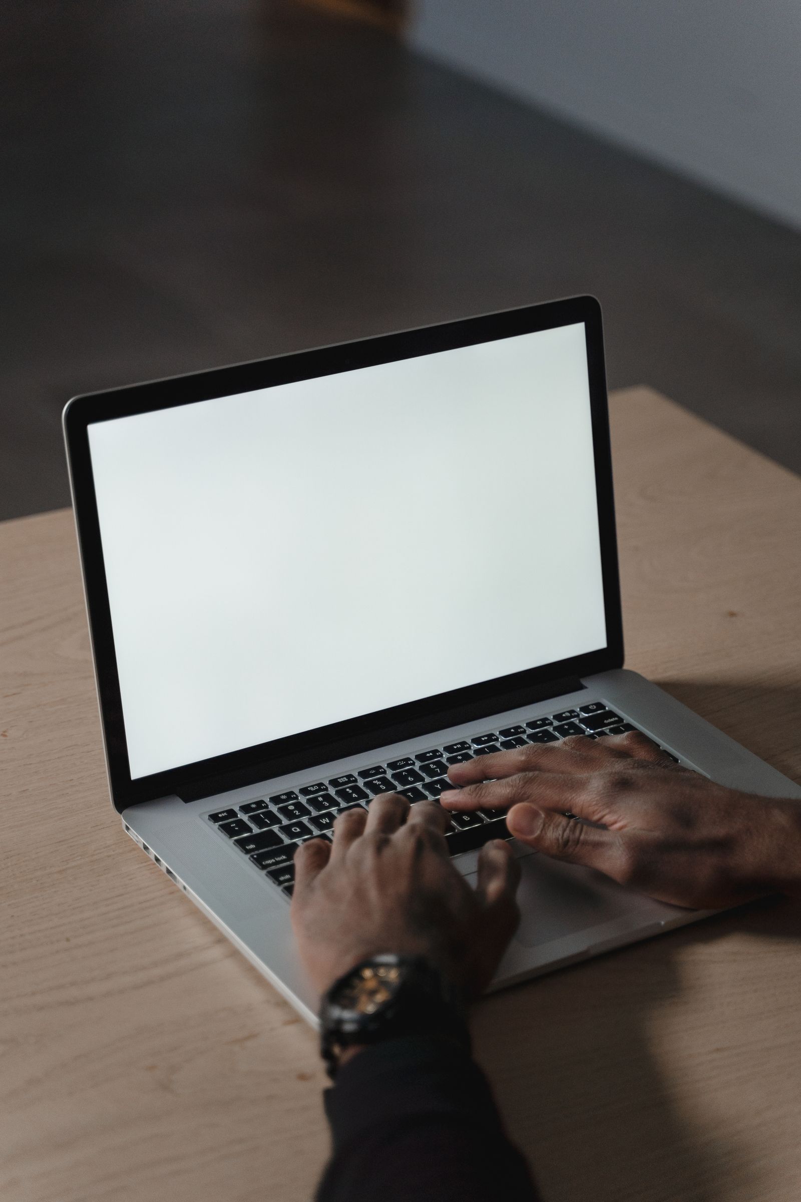 Person using a laptop with a blank screen