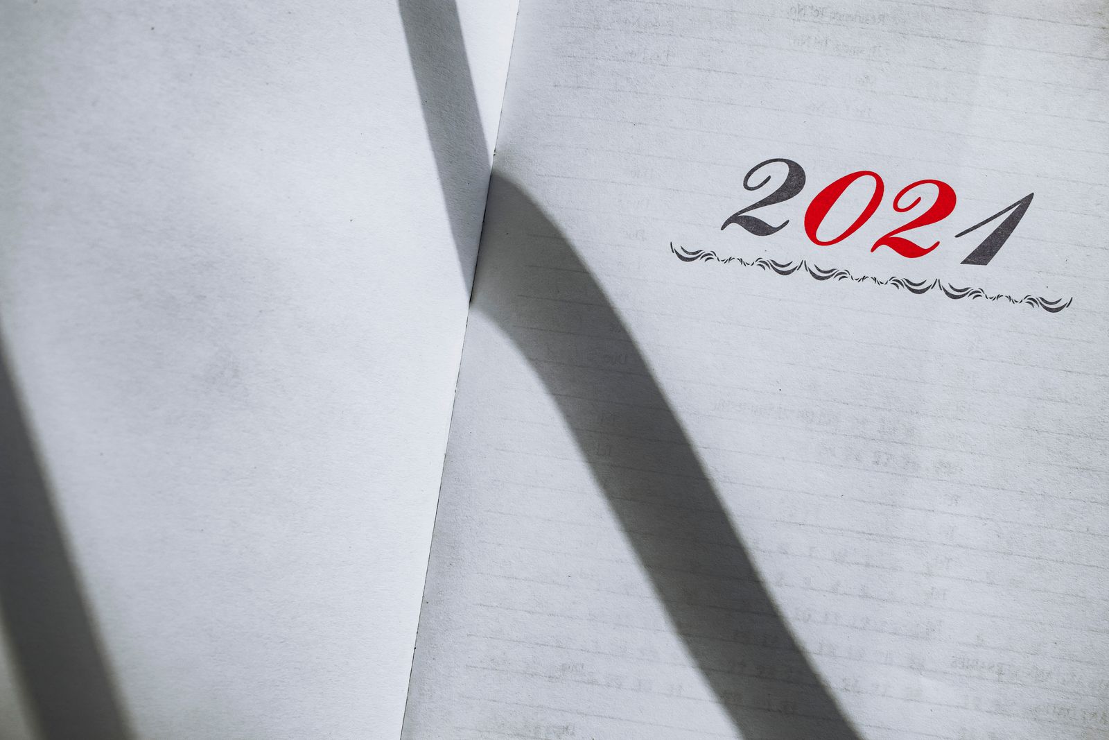 Close-up of an open planner showing the year with minimalist styling and shadows
