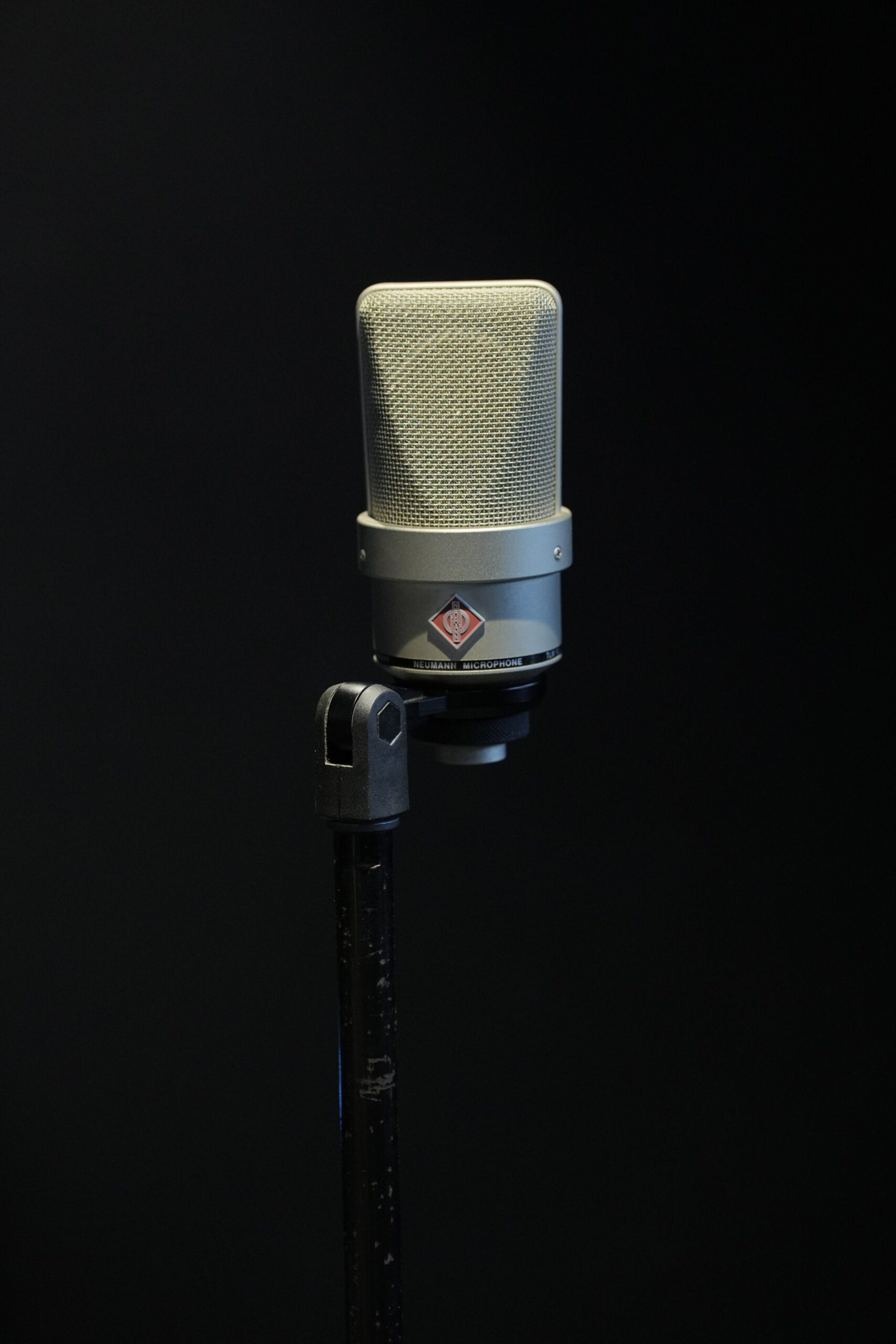 Studio microphone against a dark backdrop, perfect for audio production themes.
