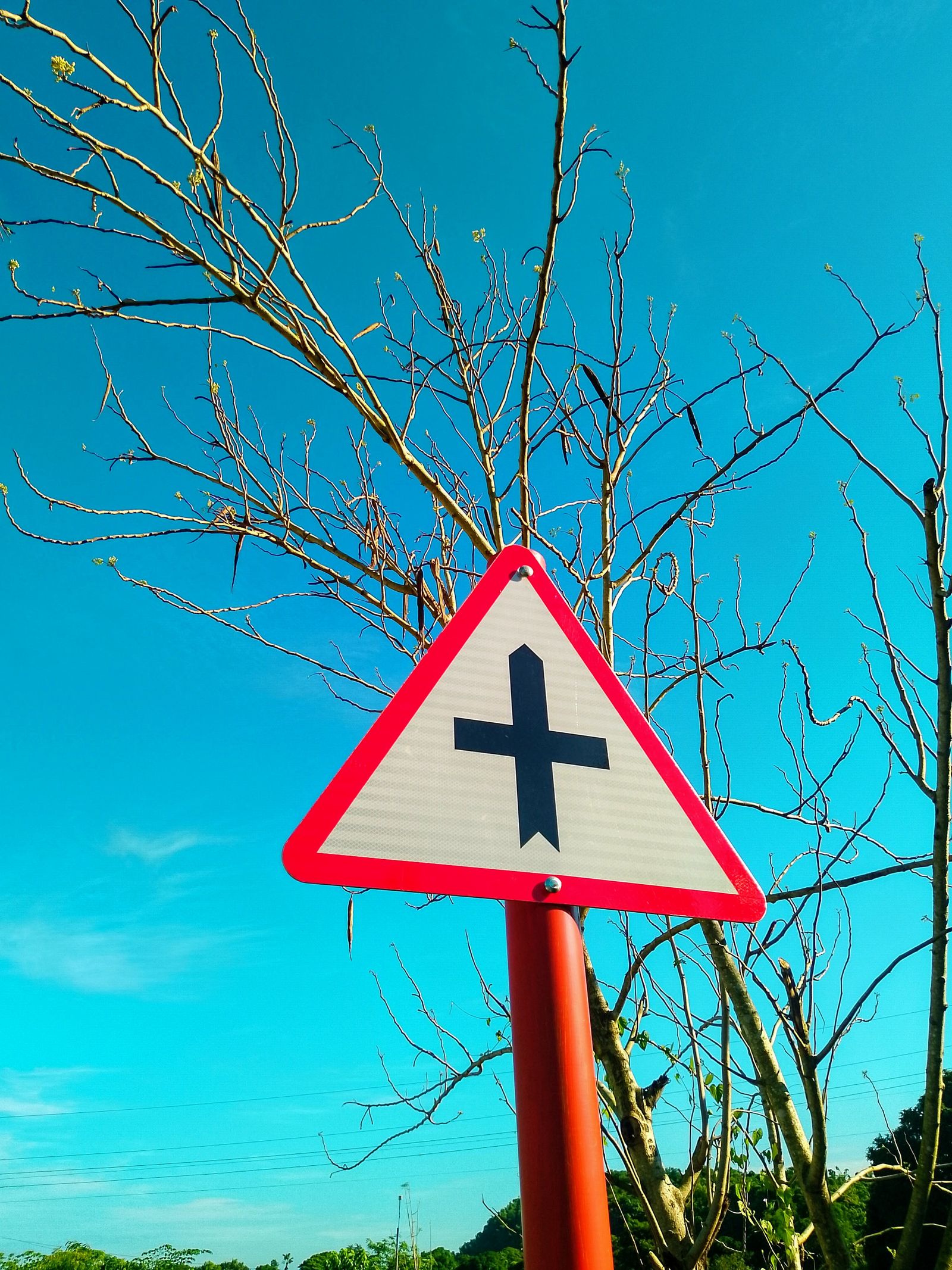 Triangular traffic sign against a blue sky
