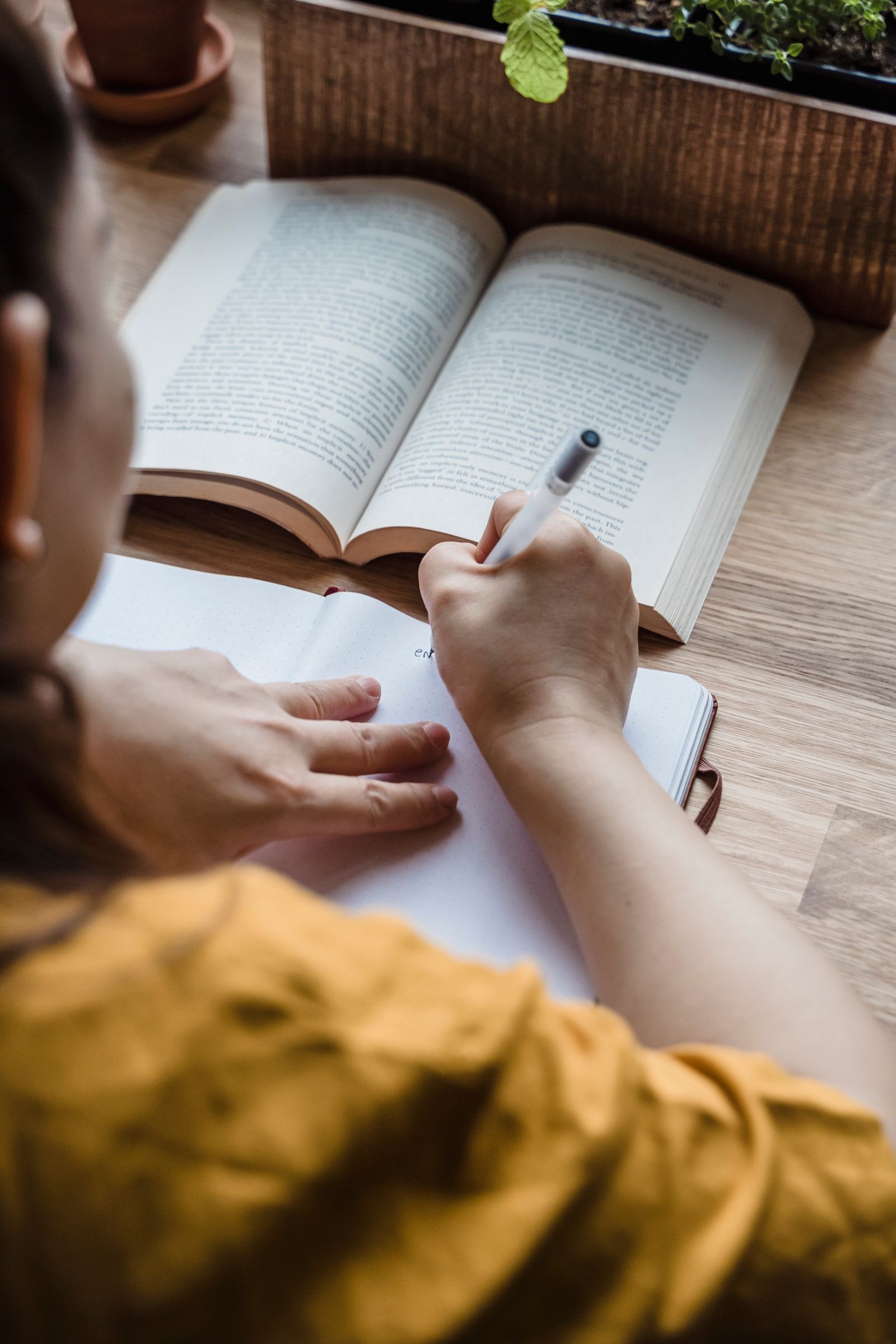 Hand writing verb conjugations in a study notebook