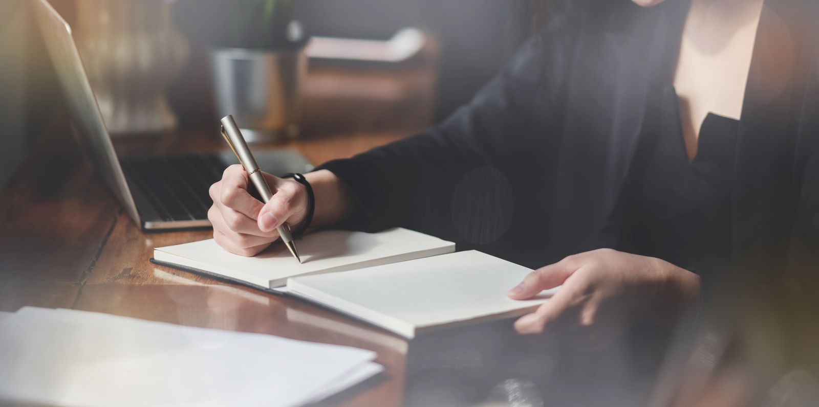 Person journaling with coffee on desk
