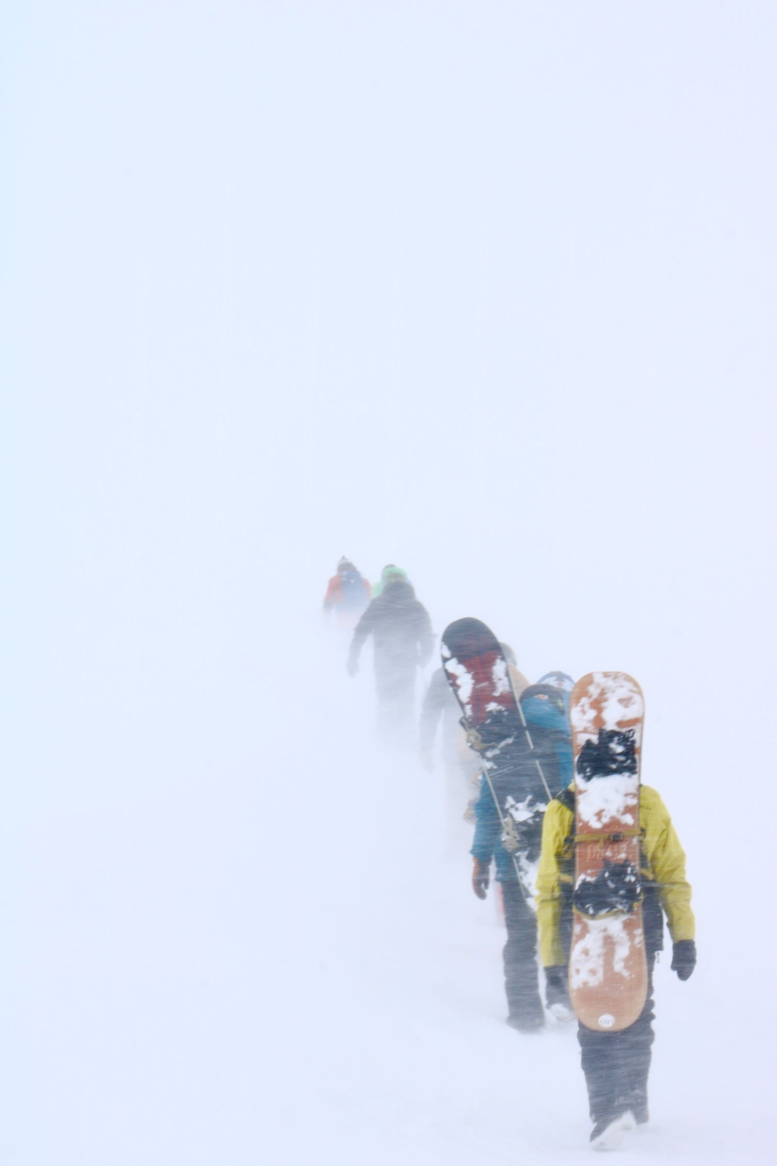 Adventurous hikers traverse a snowy path amidst a blizzard