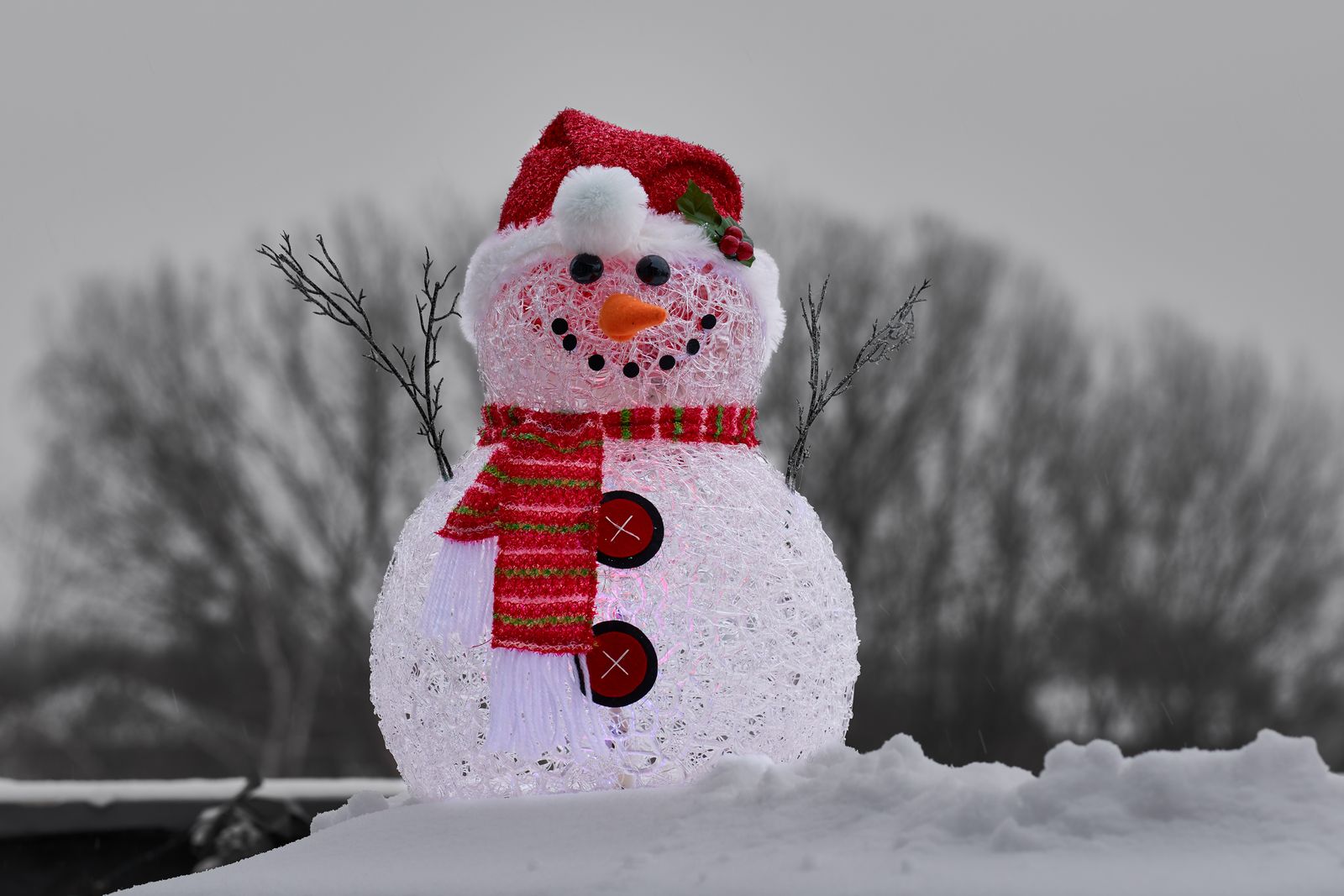 Close-up of a glistening snowman with scarf and hat in a snowy winter scene