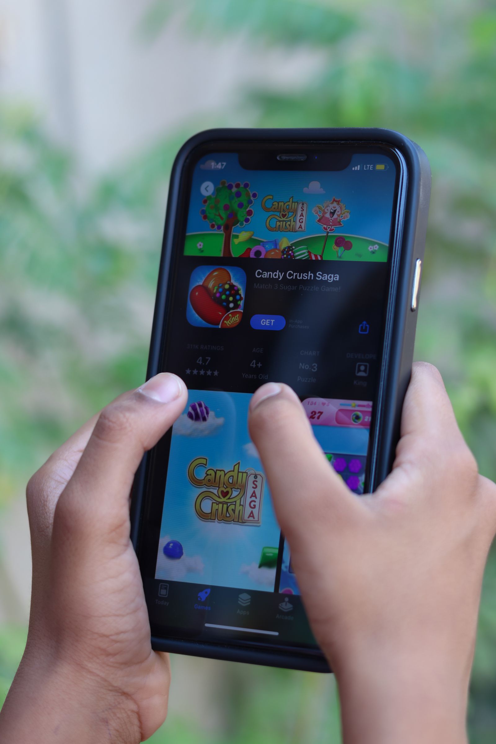 Close-up of hands playing a game on a smartphone touchscreen
