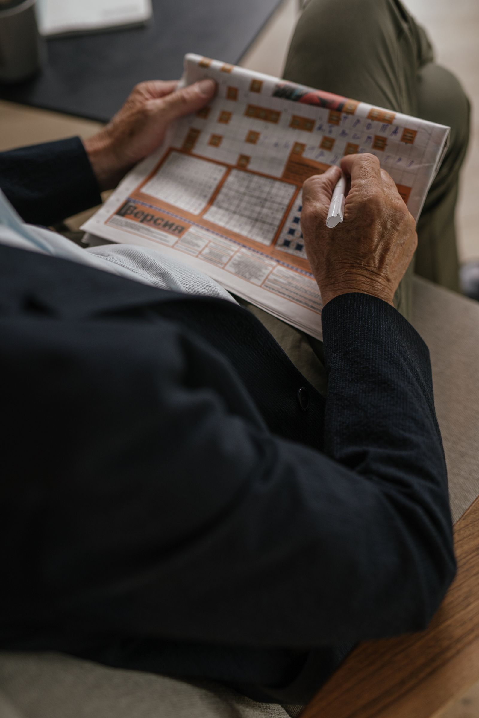Senior adult solving a crossword puzzle in a newspaper