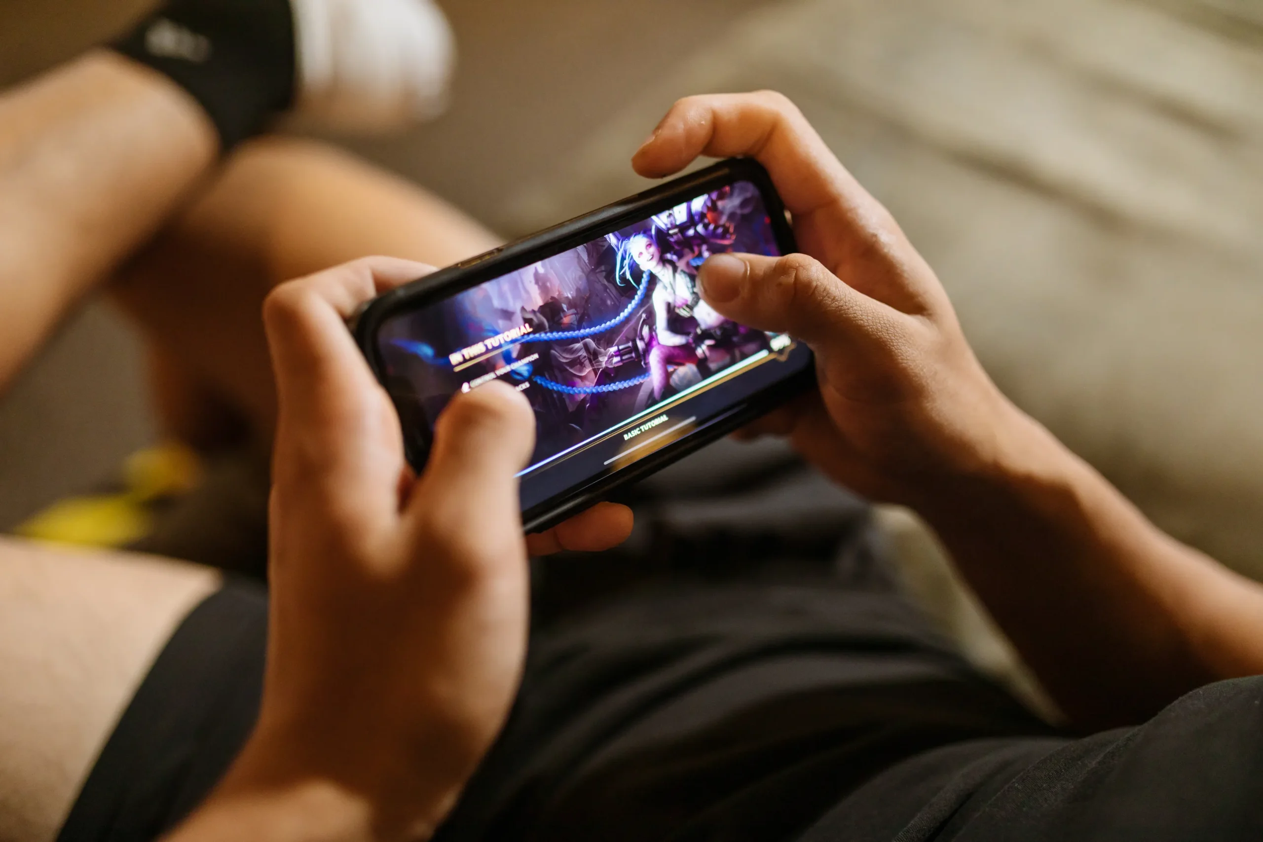 Hand holding a smartphone while playing a mobile game