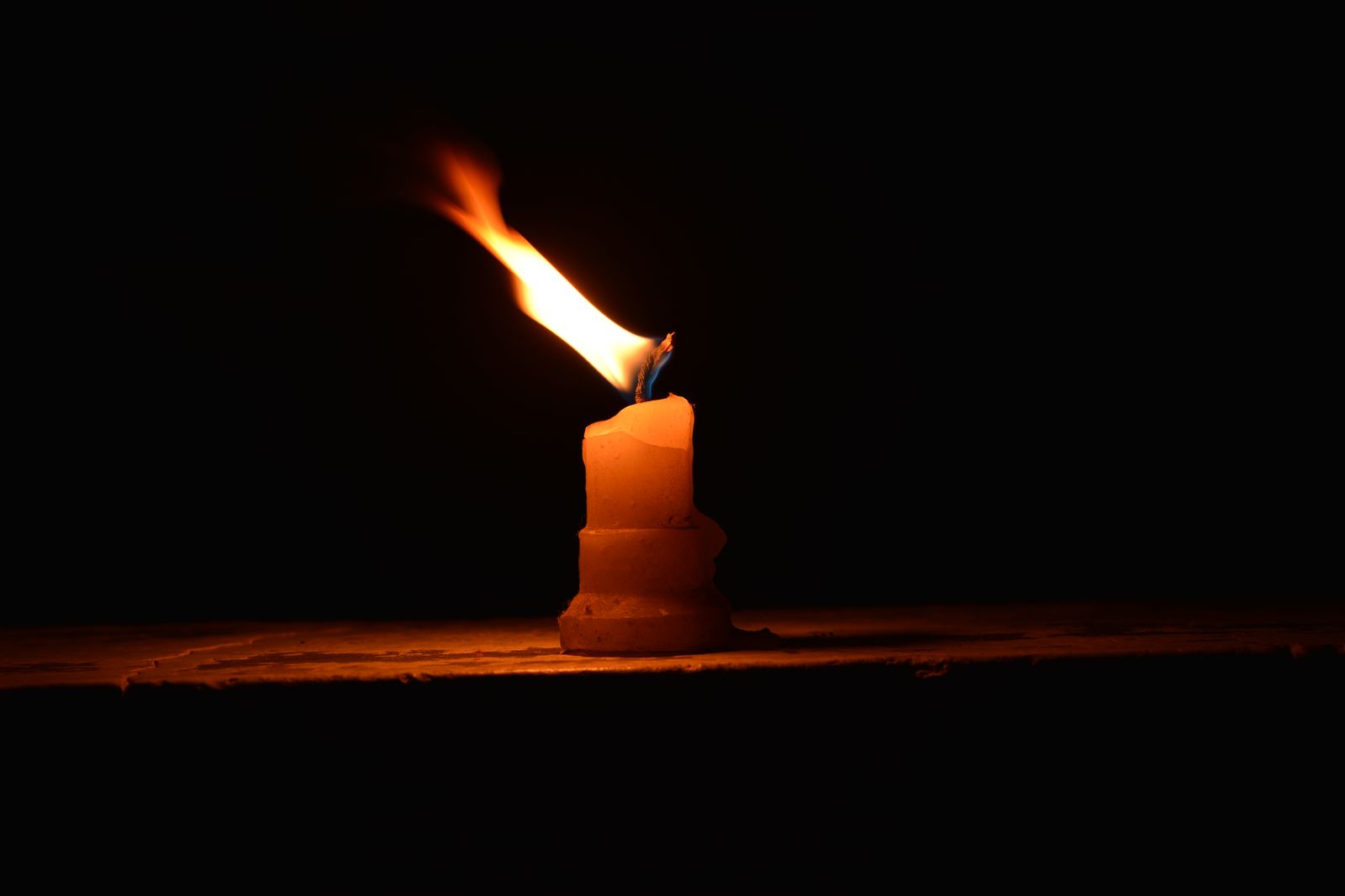 Single candle burning at night