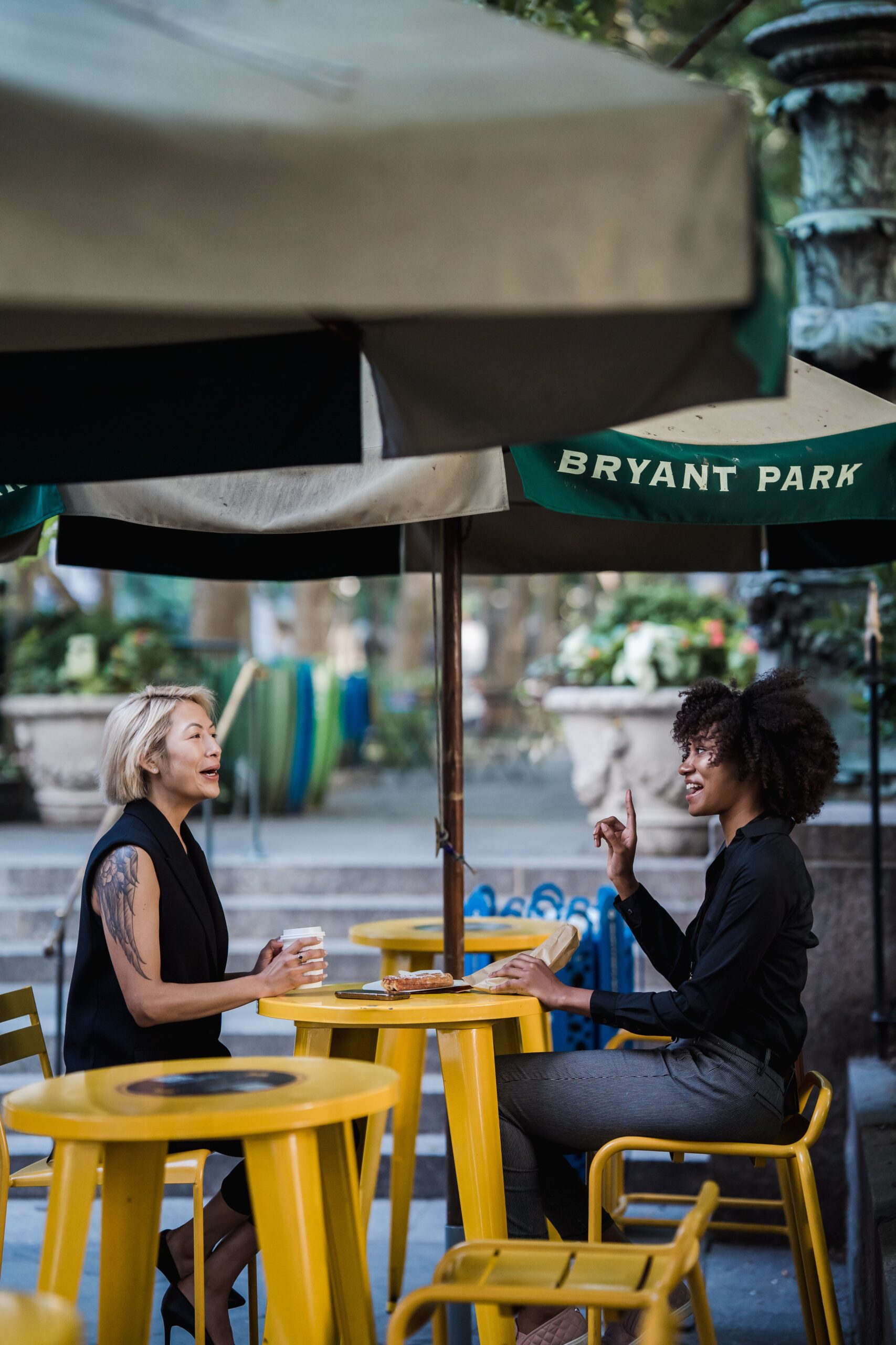 Two women enjoying a lively conversation at a cafe