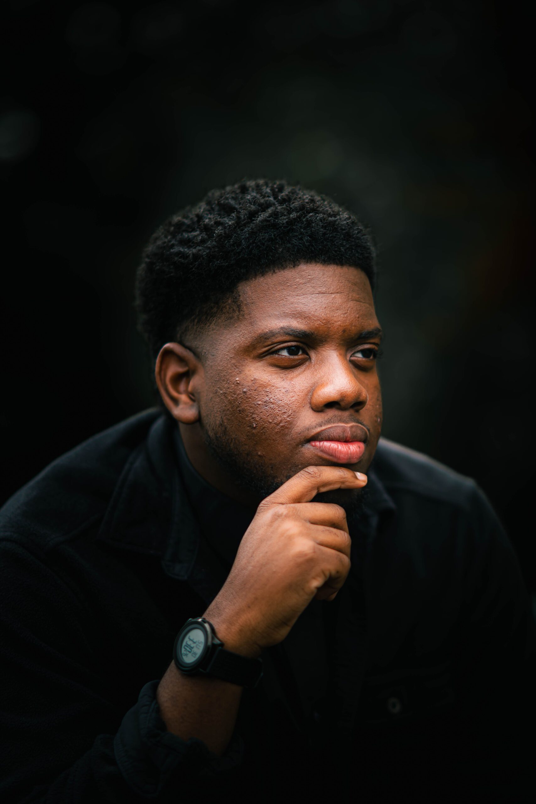 Moody portrait of a man in thought against a dark background