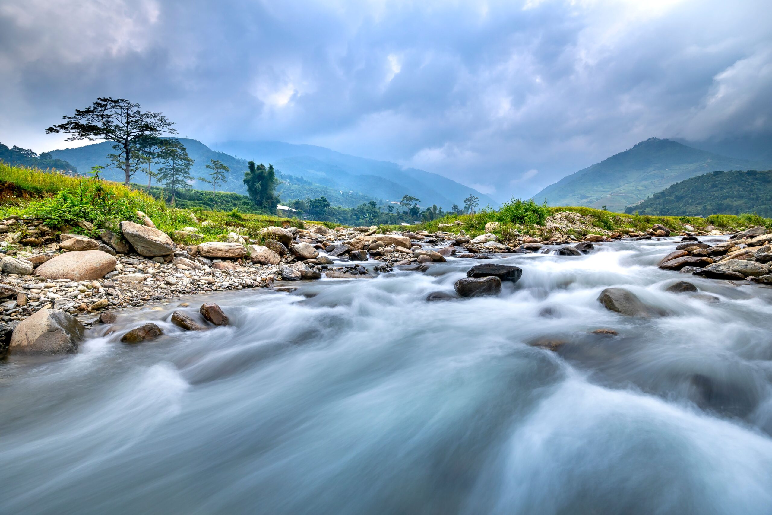 Wide river flowing through green countryside landscape