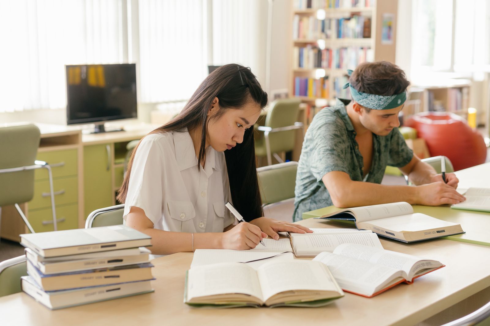Students studying at tables in a university library