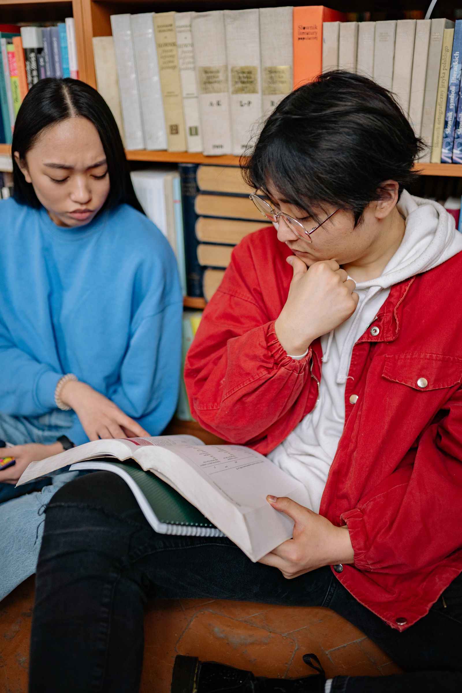 Two people studying together at a wooden table