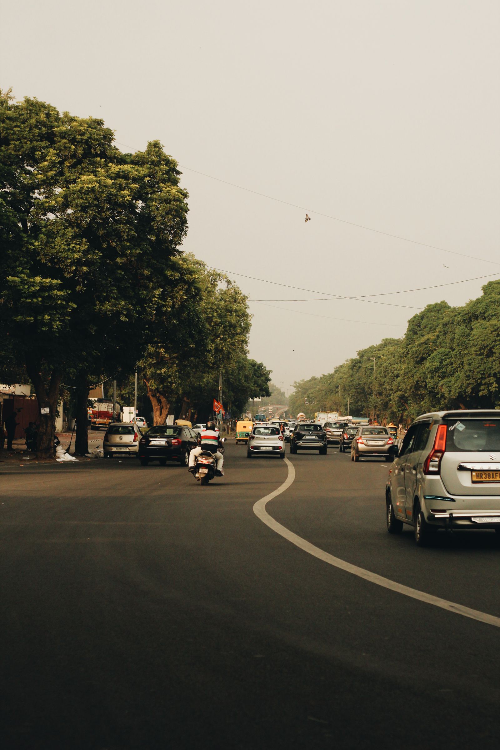 Cars and a motorcycle driving on a city street