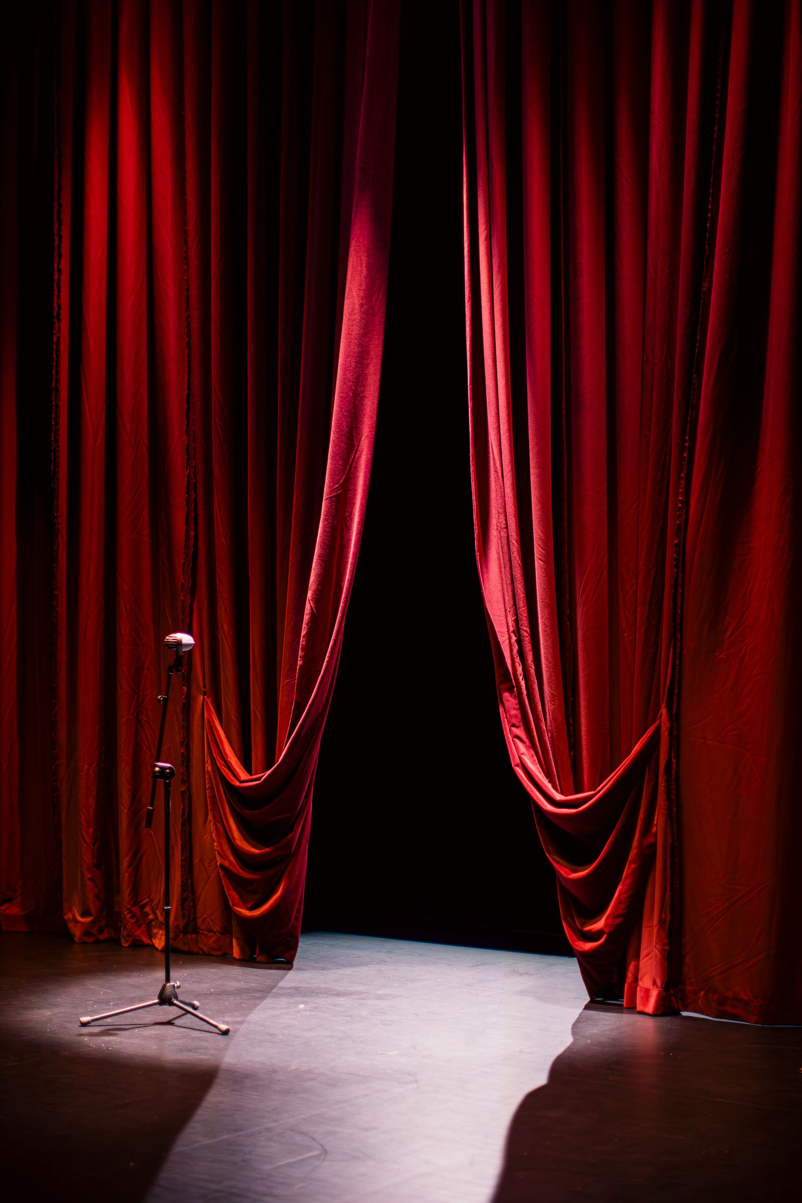 Theater stage with red curtains under spotlights