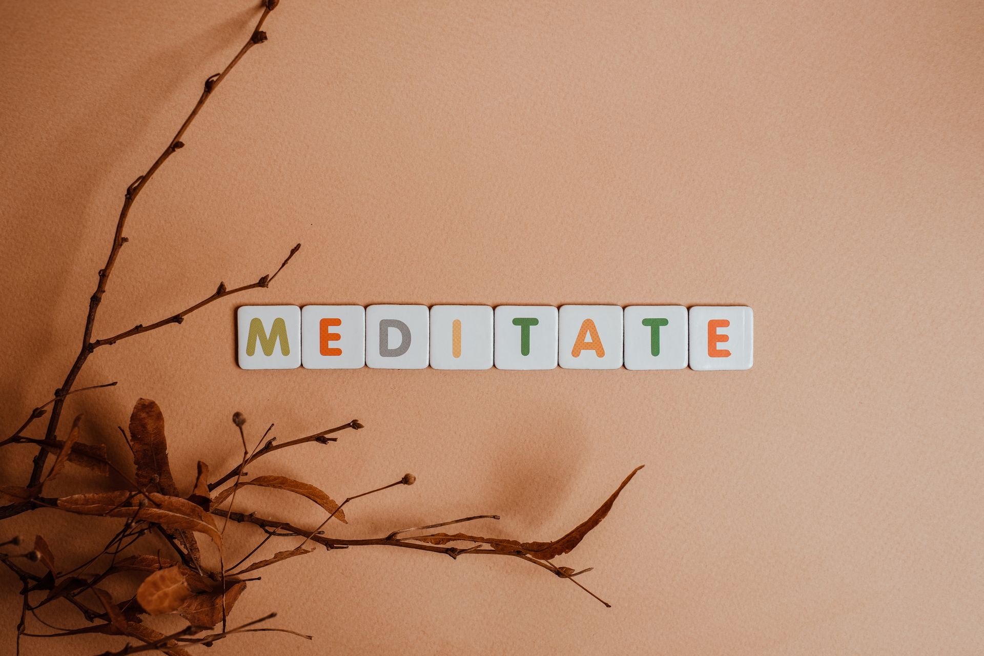 Alphabet blocks spelling meditate on a textured surface