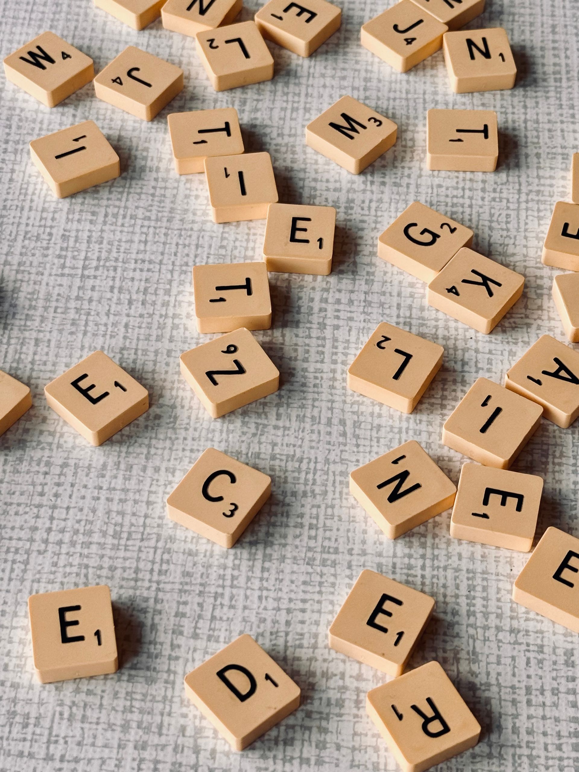 Scrabble tiles with letters and point values on texture