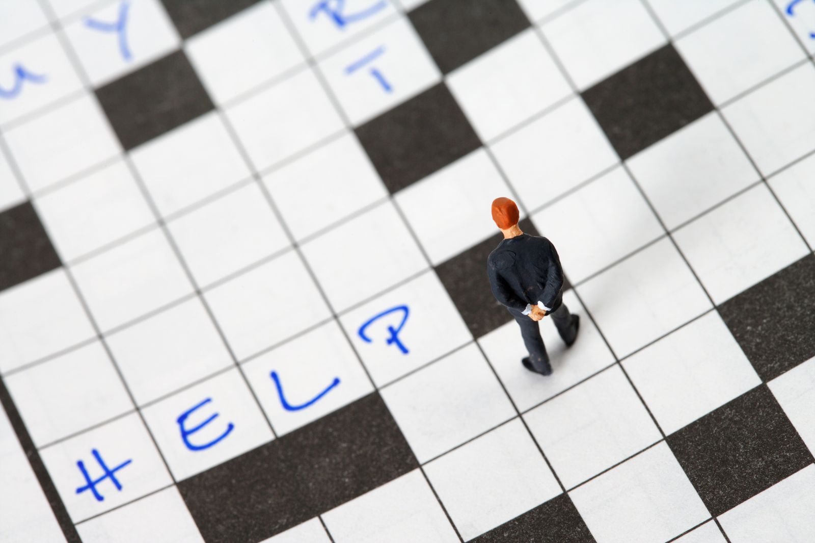 Tiny figurine searching for answers on a crossword puzzle