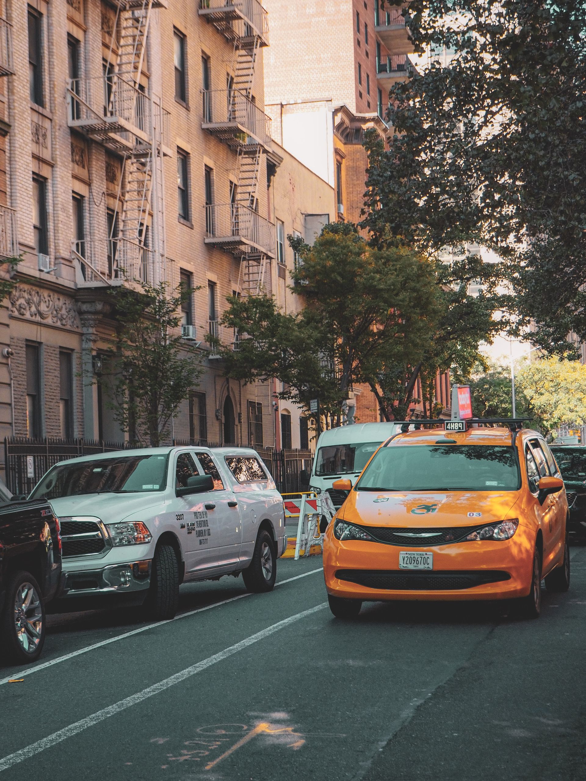 Mellow streets of New York City with iconic yellow taxis and fire escapes.