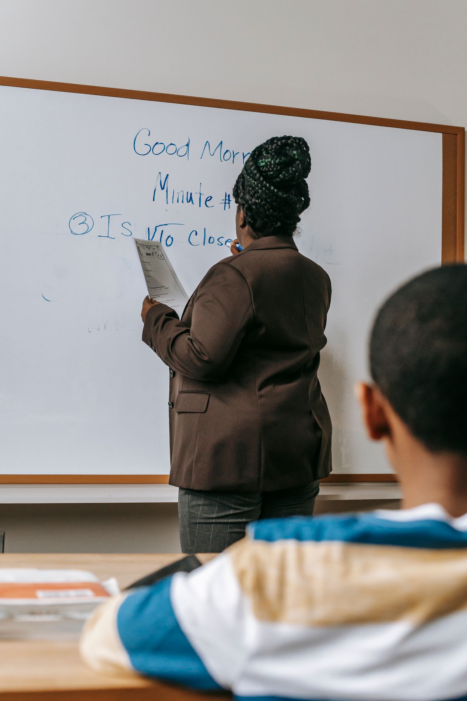 Teacher explaining at a whiteboard in a classroom