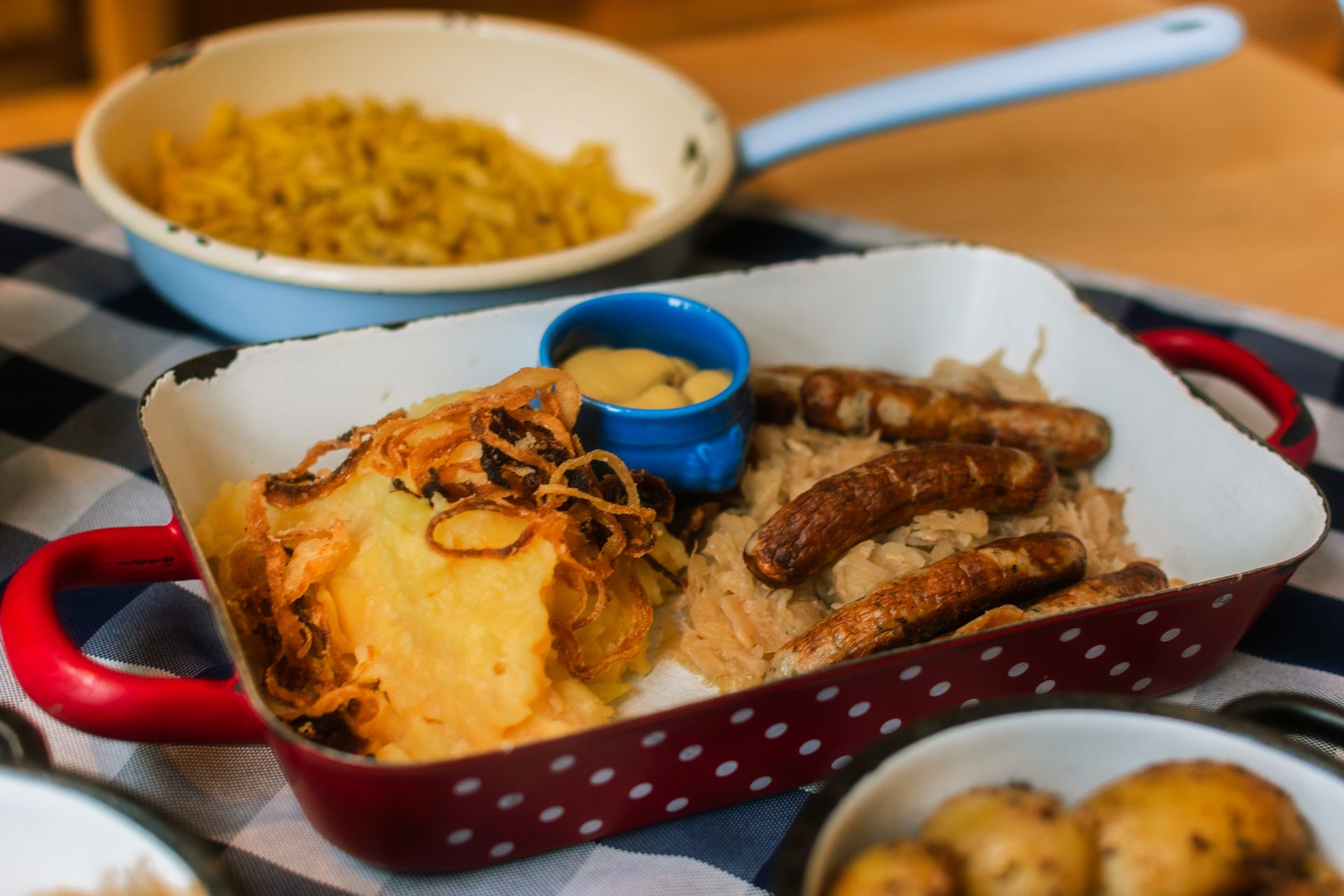 German sausages with potatoes, sauerkraut, and mustard in a rustic setting