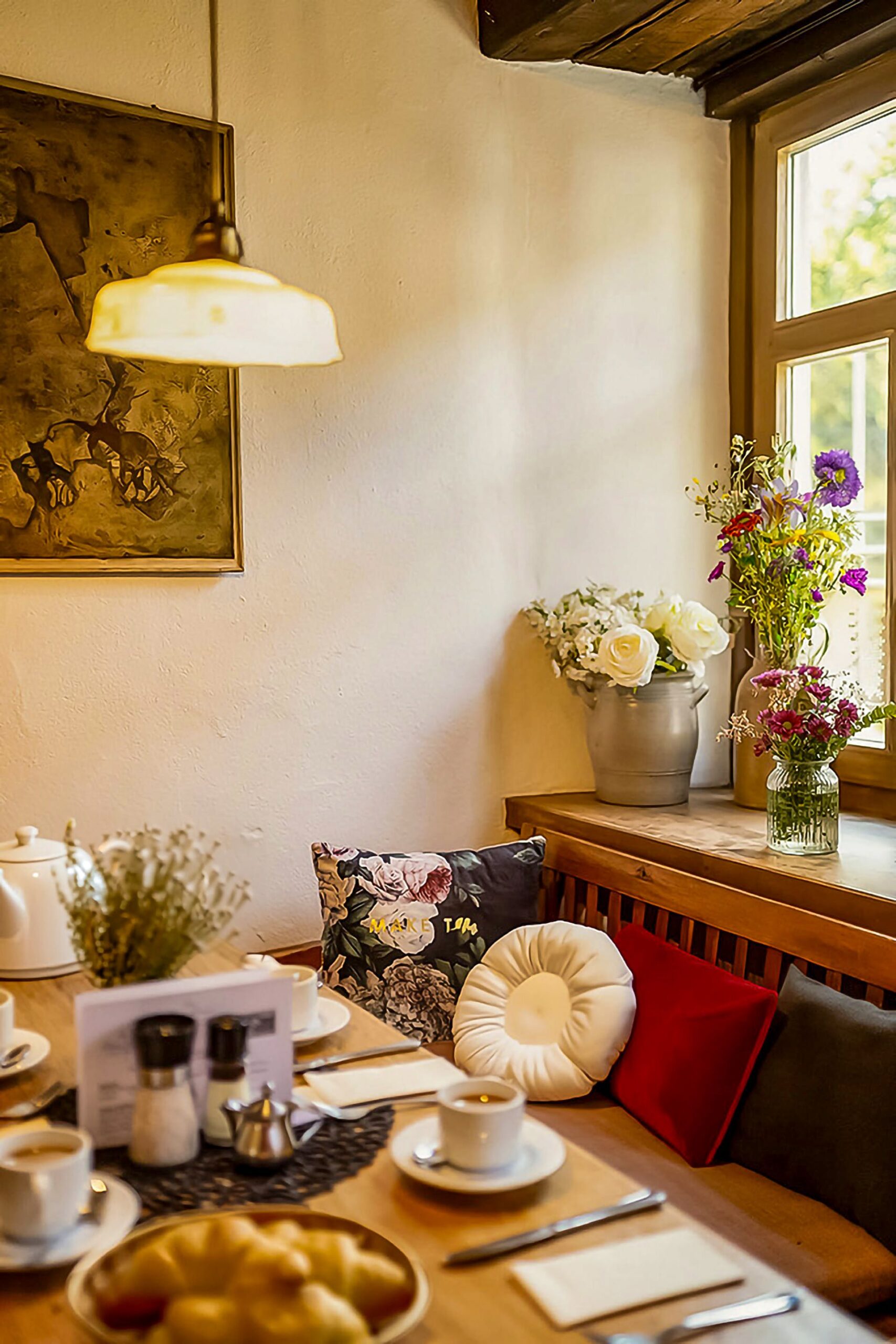 Cozy German café corner with coffee cups, croissants, and fresh flowers