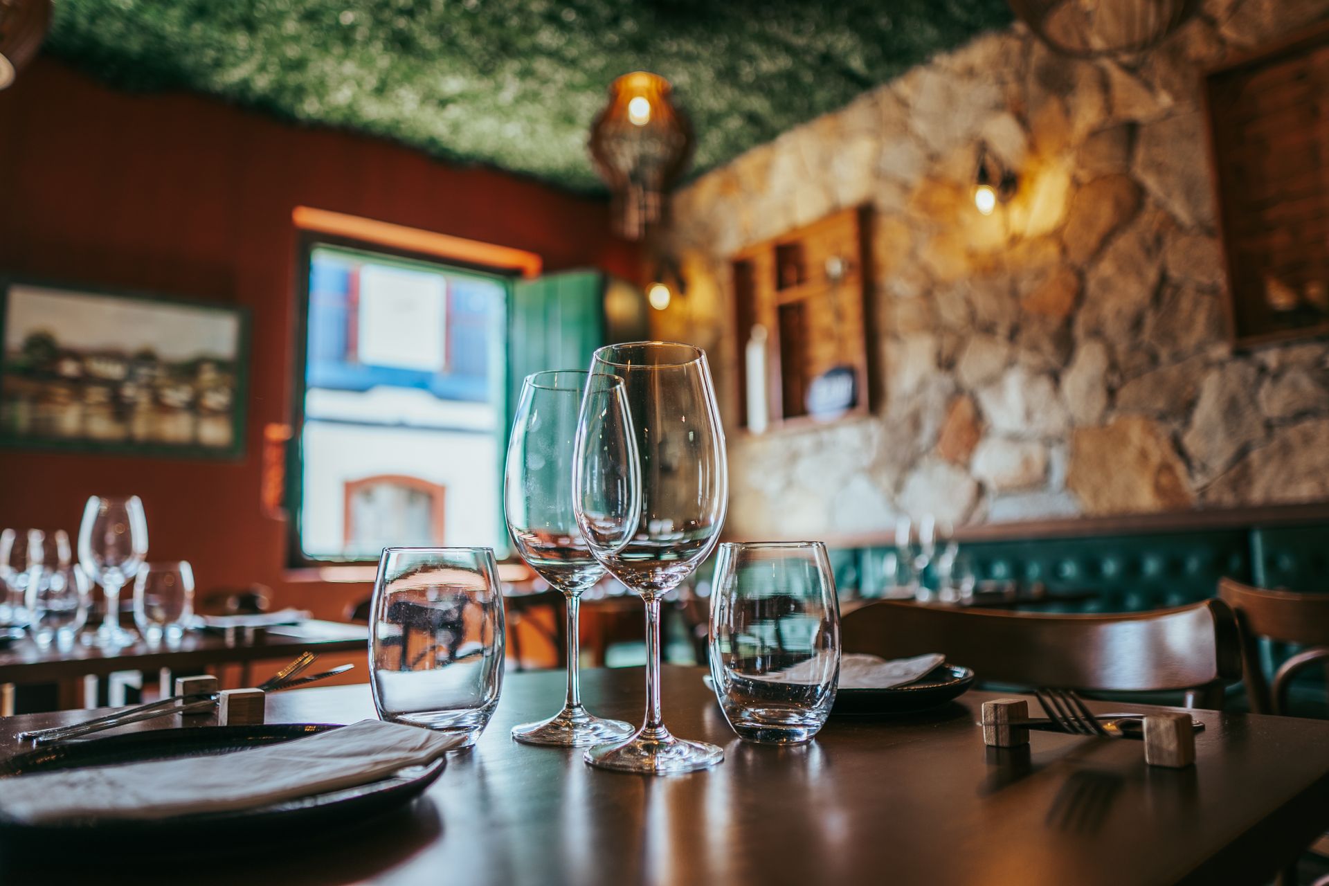 Elegant restaurant table setting with glassware and stone walls