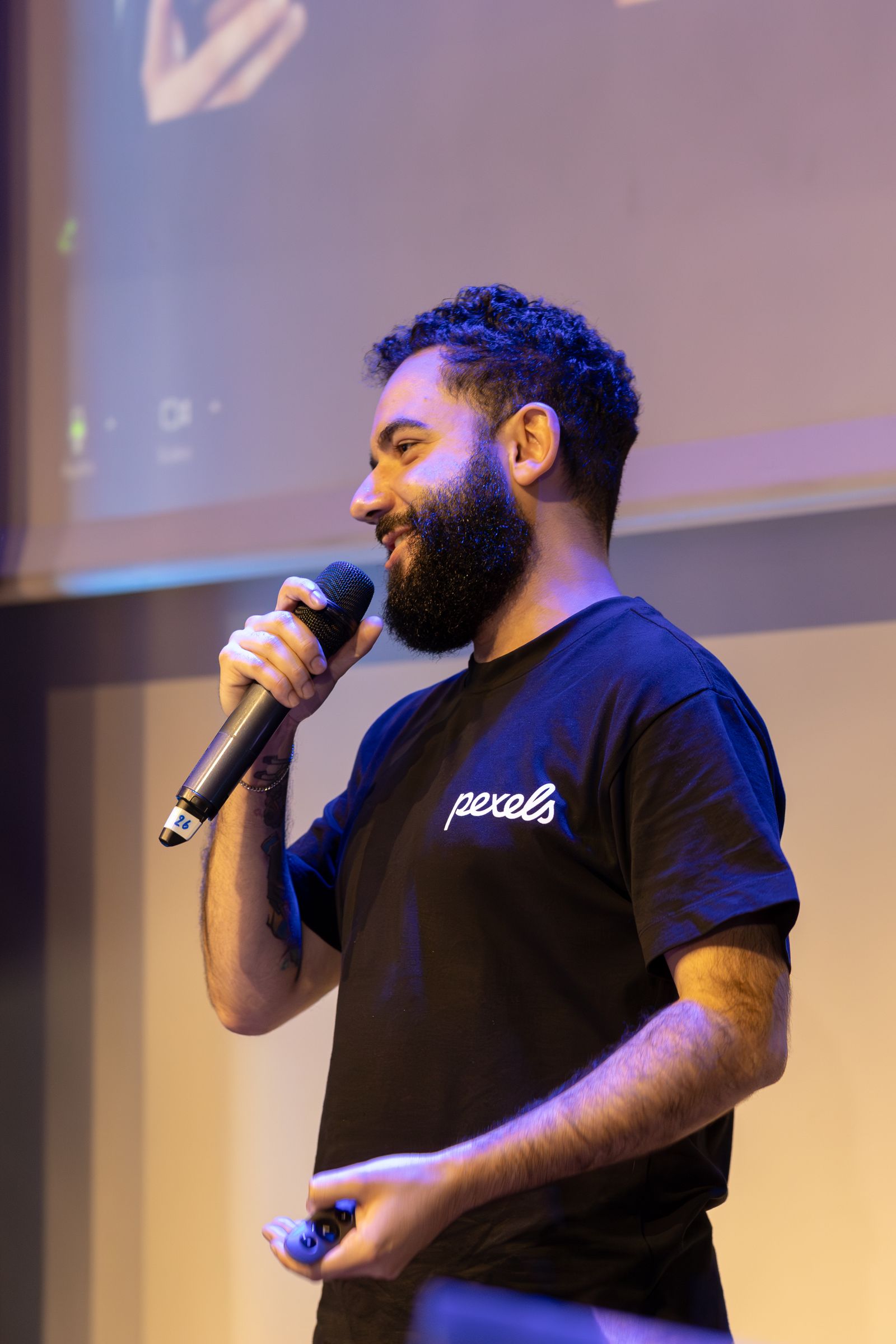 Man speaking at an indoor event with a microphone