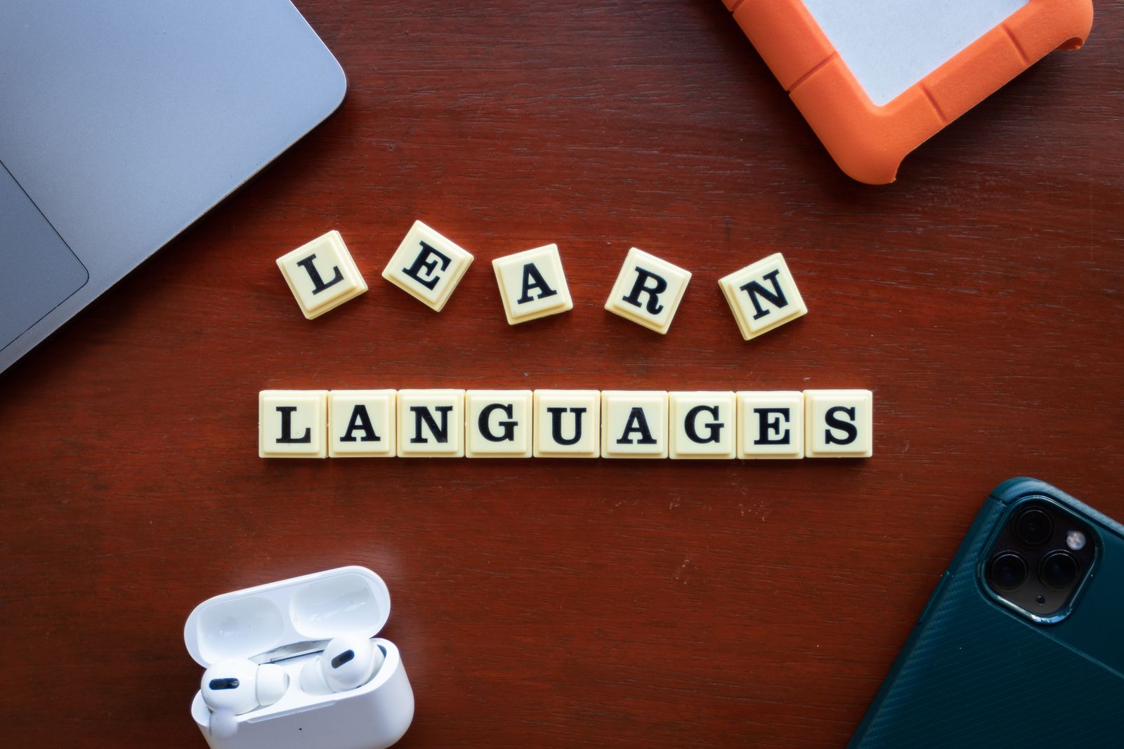 Flat lay of language learning materials and gadgets on a desk
