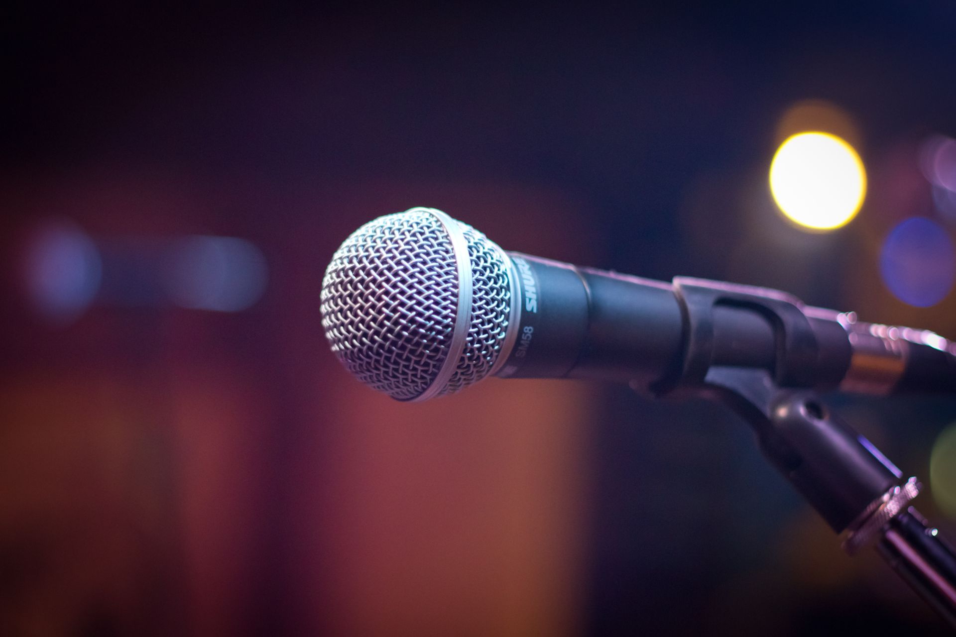 Dynamic microphone on a stand with blurred stage lights behind